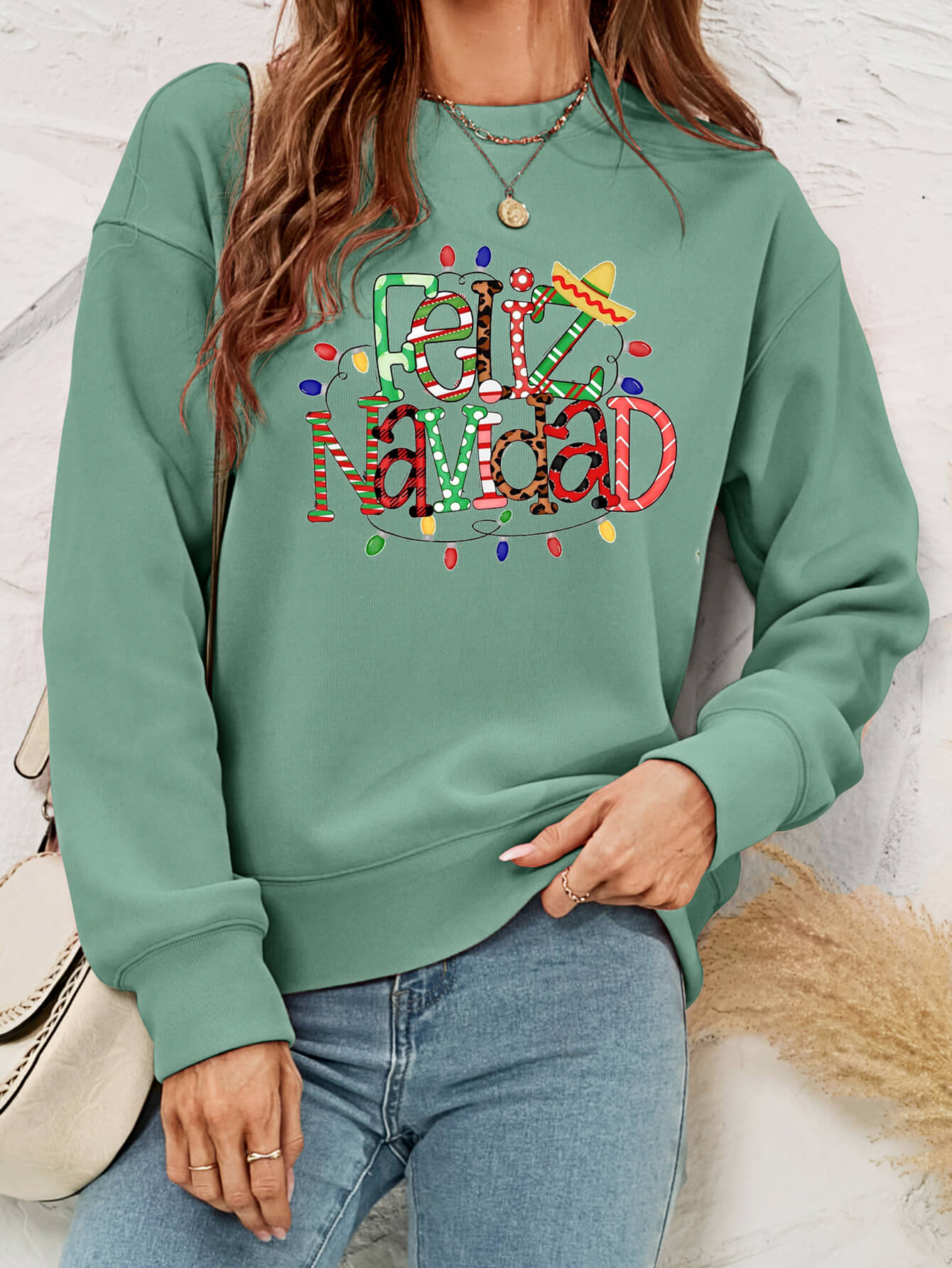 Feliz Navidad Graphic Crewneck Sweatshirt in a studio setting, featuring a festive design and casual style.