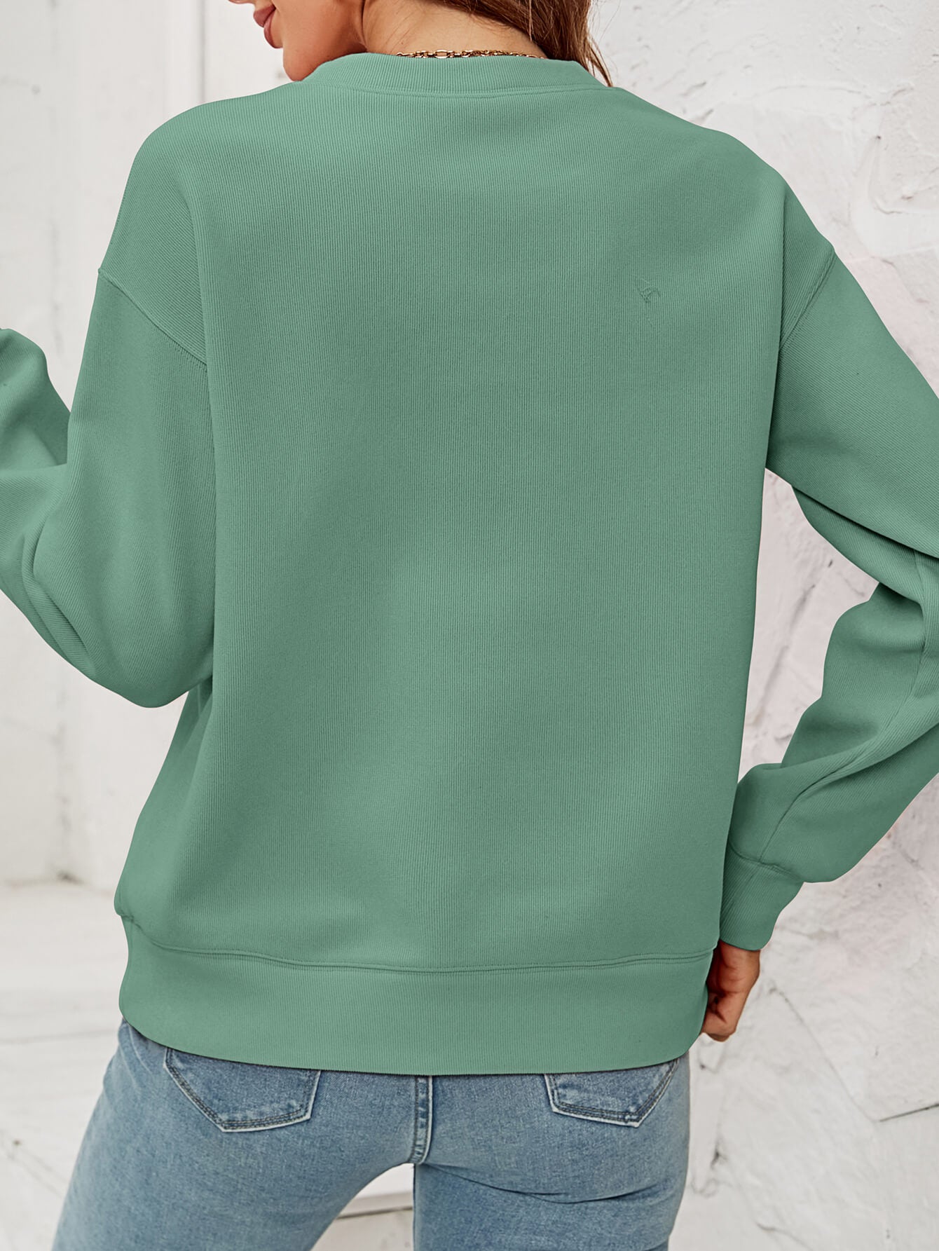 Feliz Navidad Graphic Crewneck Sweatshirt in a studio setting, featuring a festive design and casual style.