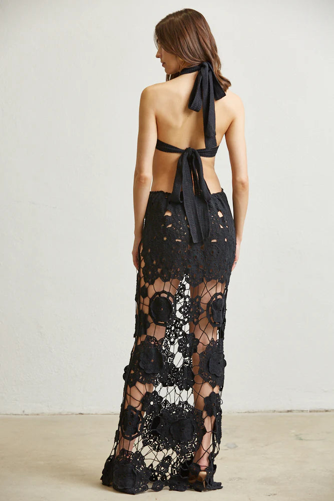 A stylish Floral Allure Crochet Dress featuring a flower medallion crochet design, tie-back halter neck, and daring see-through skirt.