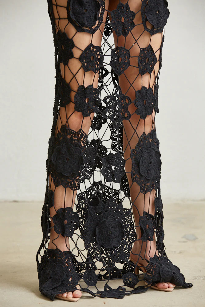 A stylish Floral Allure Crochet Dress featuring a flower medallion crochet design, tie-back halter neck, and daring see-through skirt.