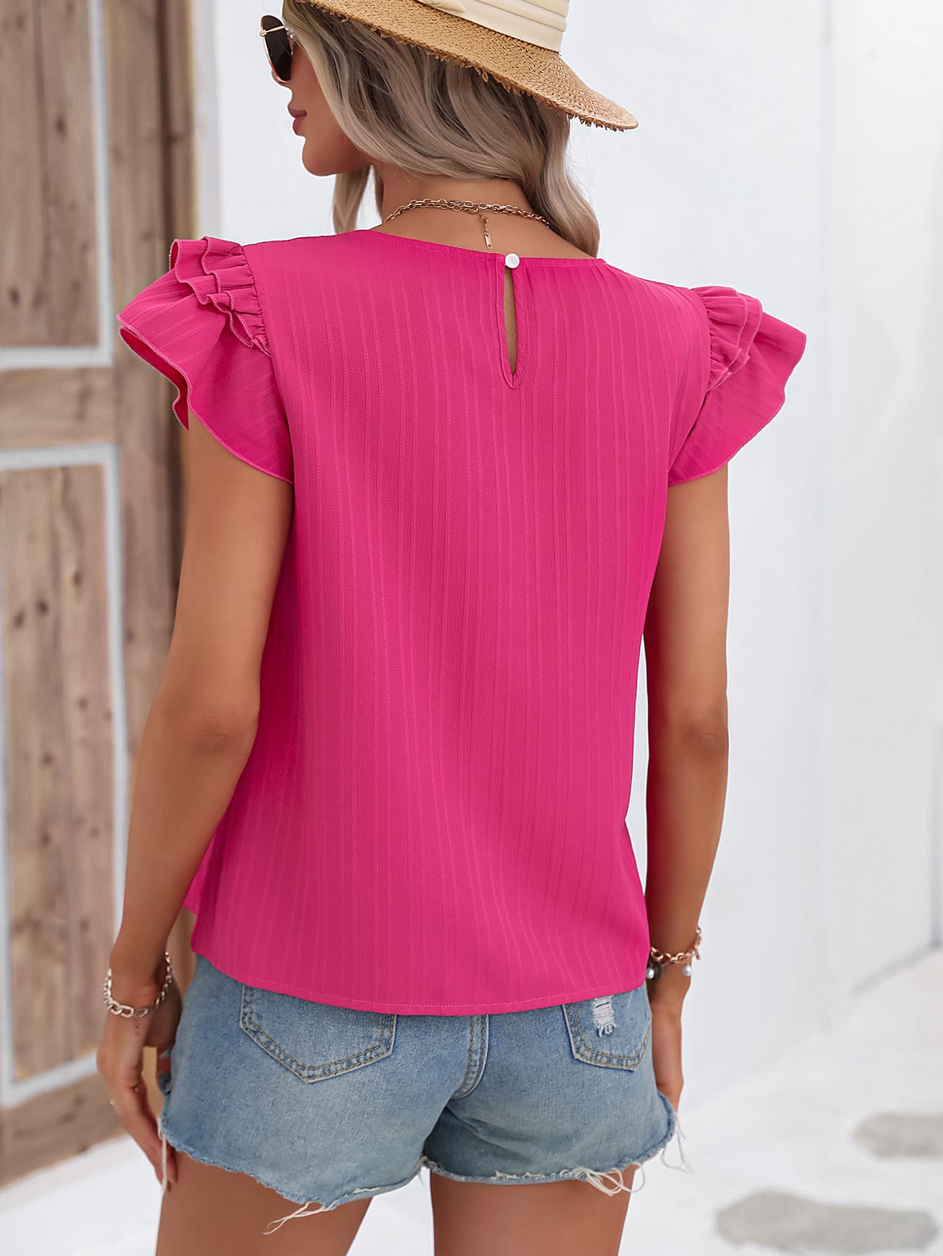 A stylish Flutter Sleeve Round Neck Blouse featuring chic ruffles and cap sleeves, made from 100% polyester in a solid color.