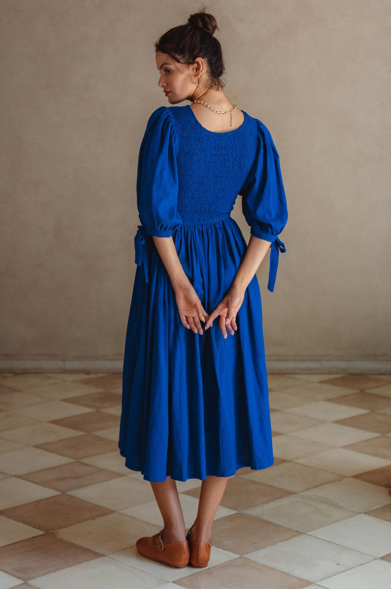 Freya Smocked Linen Midi Dress featuring a smocked bodice and tie-up puffy sleeves in a beautiful crinkle linen fabric.