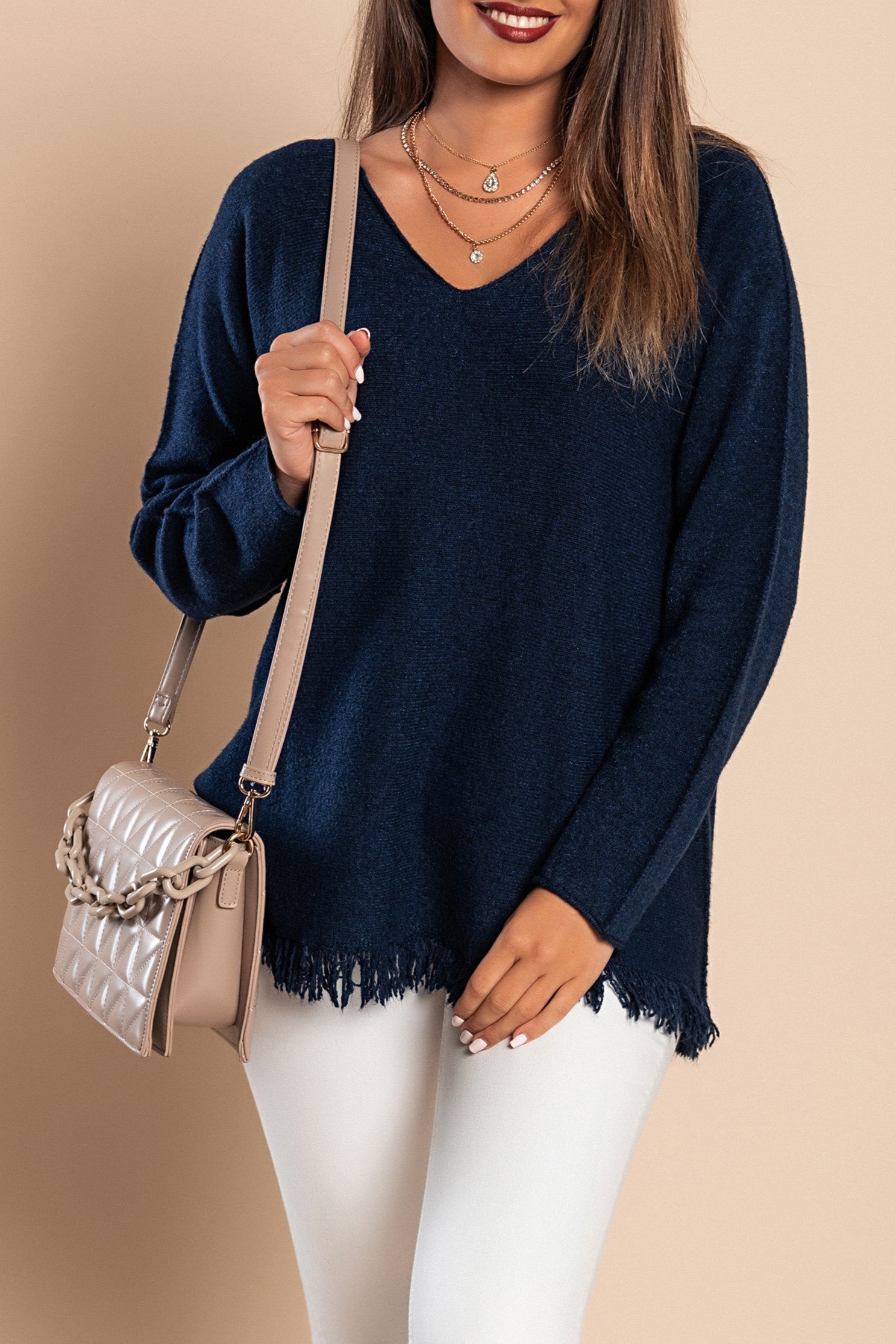 A stylish dark blue fringed sweater featuring a V-neckline and long sleeves, made from soft knitwear.