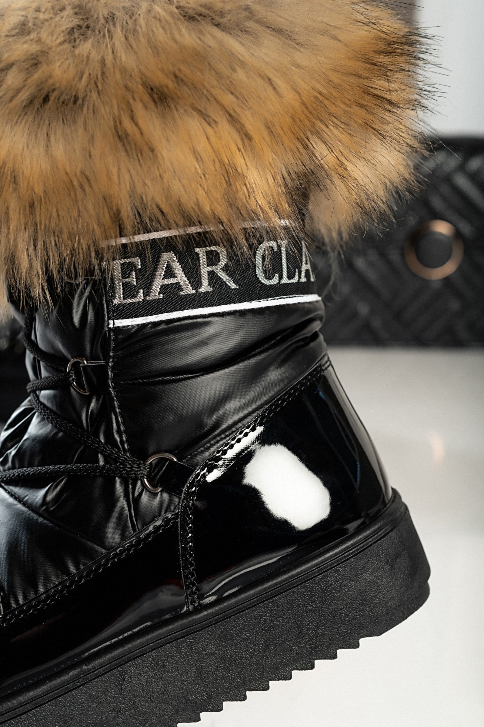 Elegantni črni gležnarji z umetnim krznom Sutera, z dvignjenim podplatom in okroglo konico, zavezani z vezalkami.