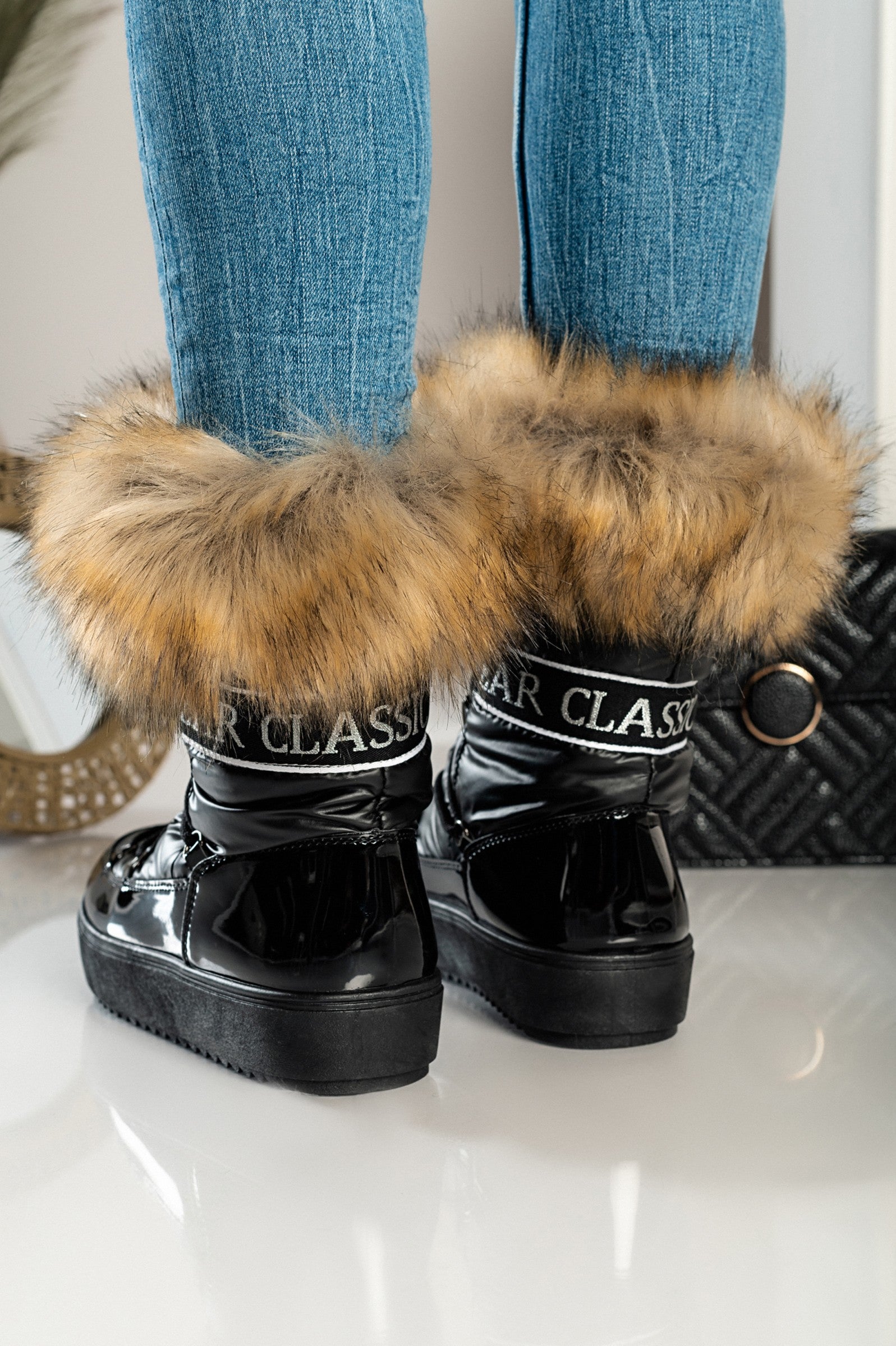 Elegantni črni gležnarji z umetnim krznom Sutera, z dvignjenim podplatom in okroglo konico, zavezani z vezalkami.