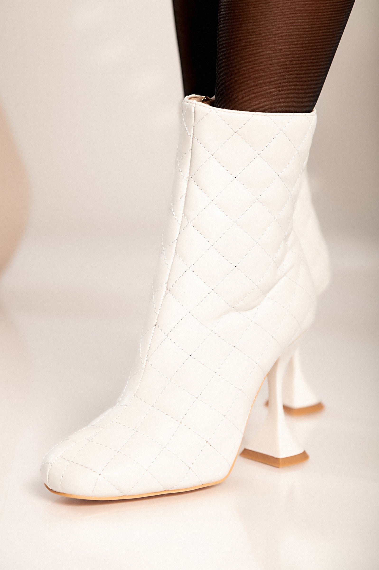 Elegantni beli gležnarji z visoko peto Lomas, prešiti vzorec in zadrga na notranji strani.