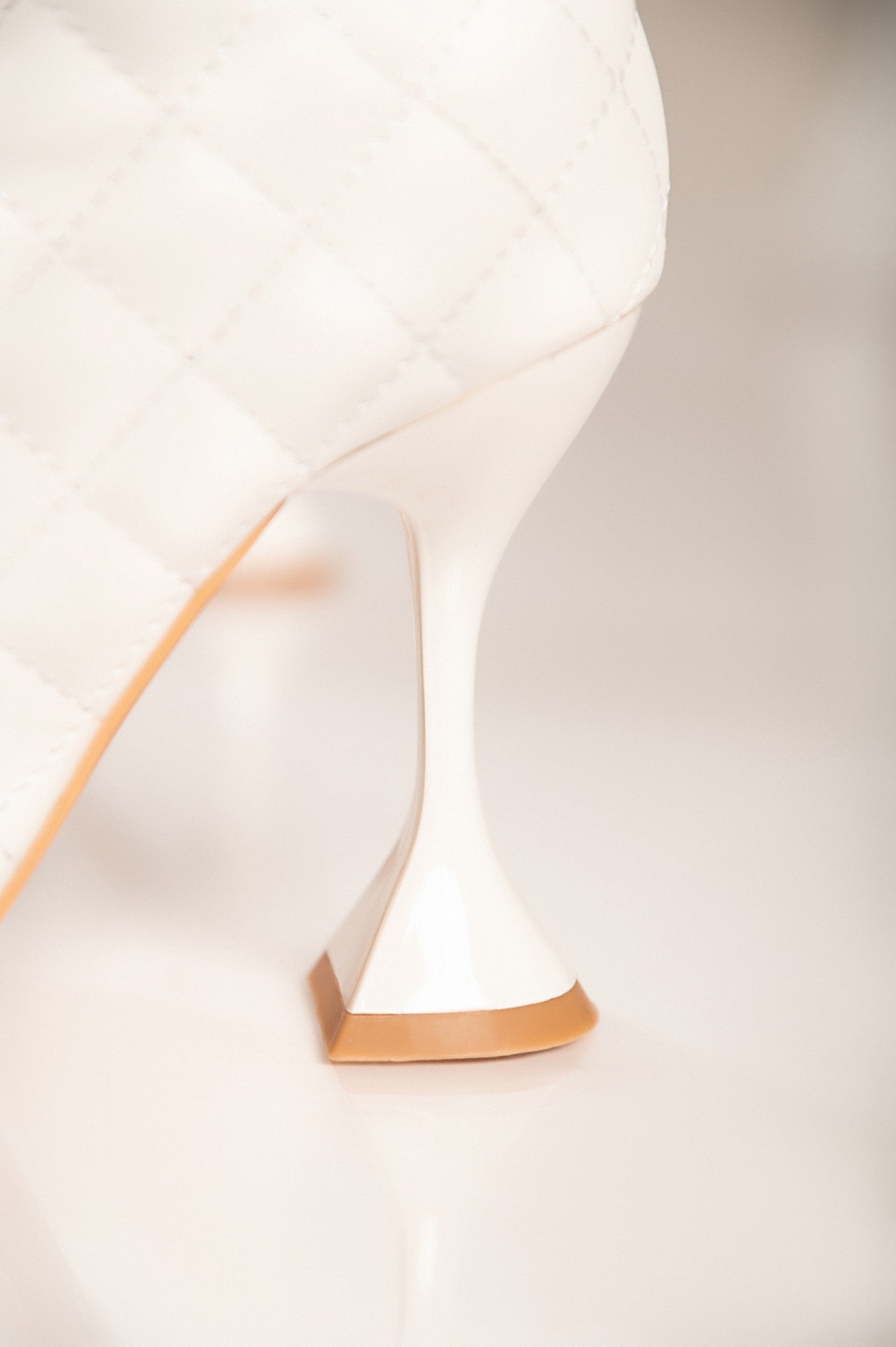 Elegantni beli gležnarji z visoko peto Lomas, prešiti vzorec in zadrga na notranji strani.