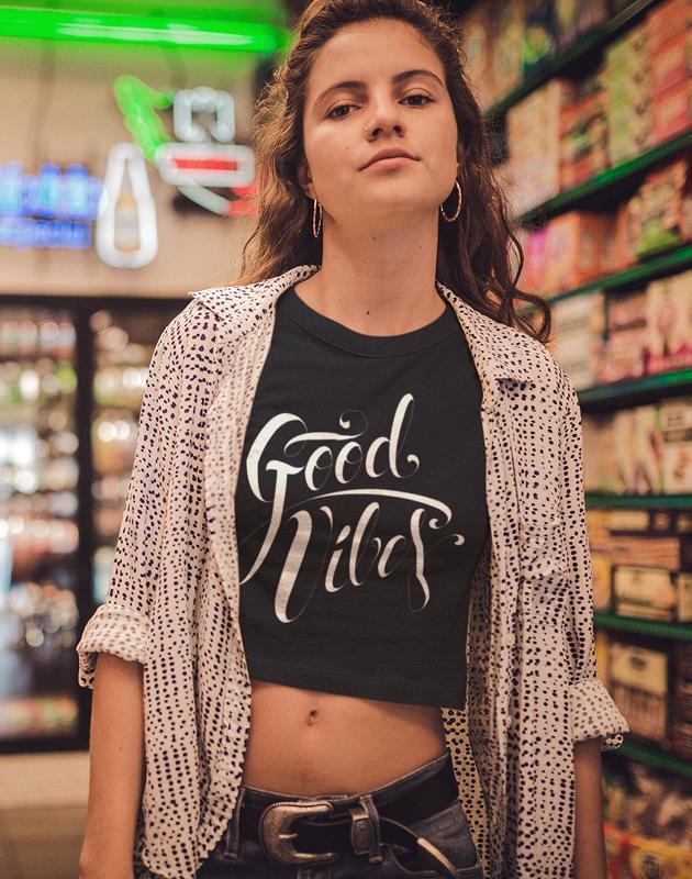 Good Vibes Type Women's Crop Top in various earth tone colors, showcasing its relaxed fit and lightweight fabric.