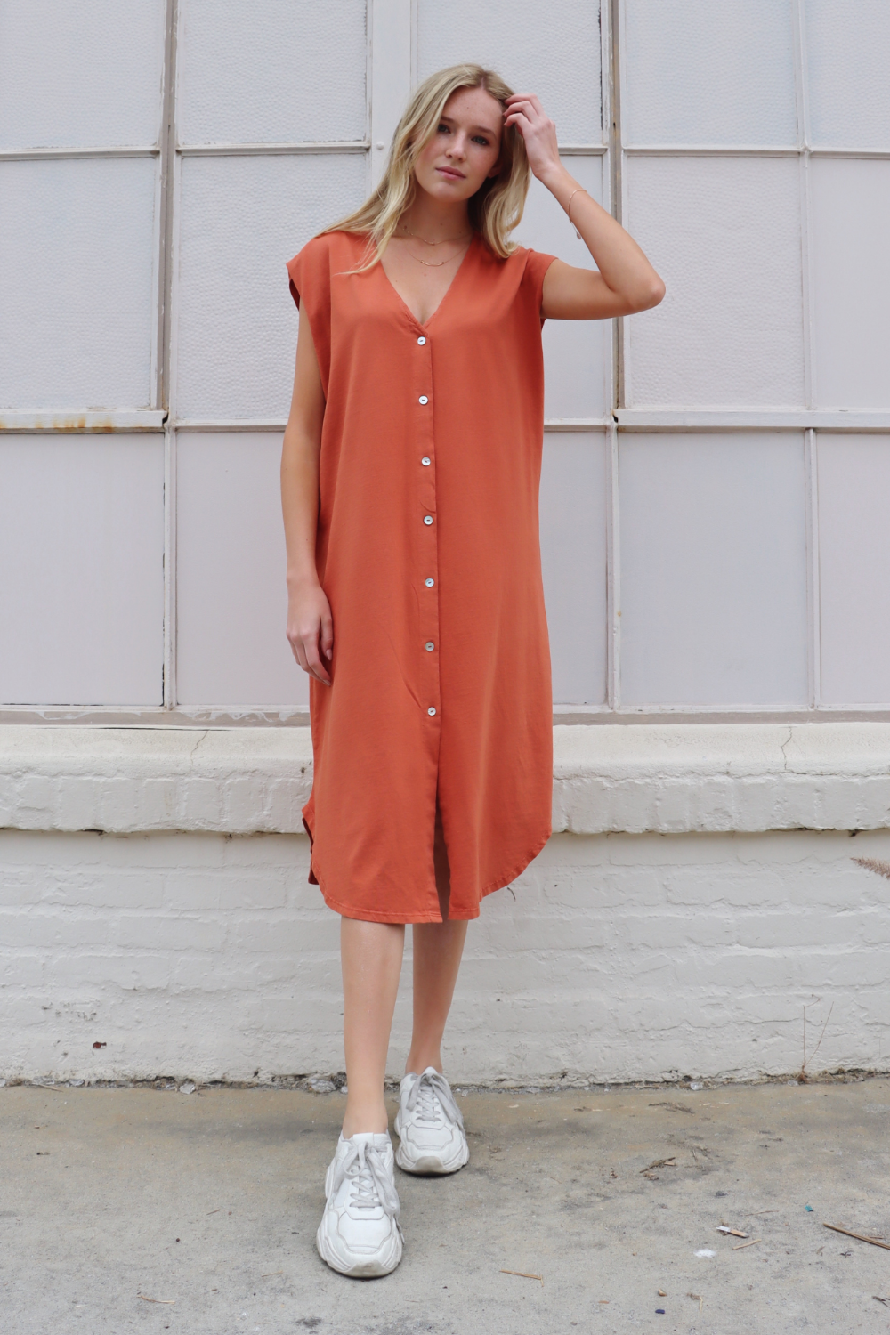 Grace Dress in olive and persimmon colors, showcasing a button-up design and flowing midi length, made from 100% organic cotton.