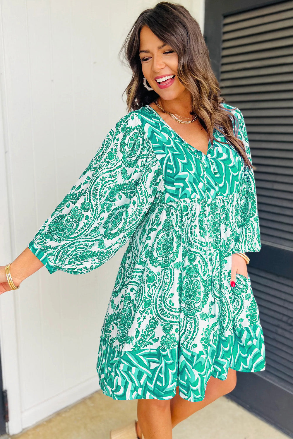A stylish green bohemian mini dress featuring puff sleeves, a tied V-neckline, and a flared silhouette, perfect for casual outings.