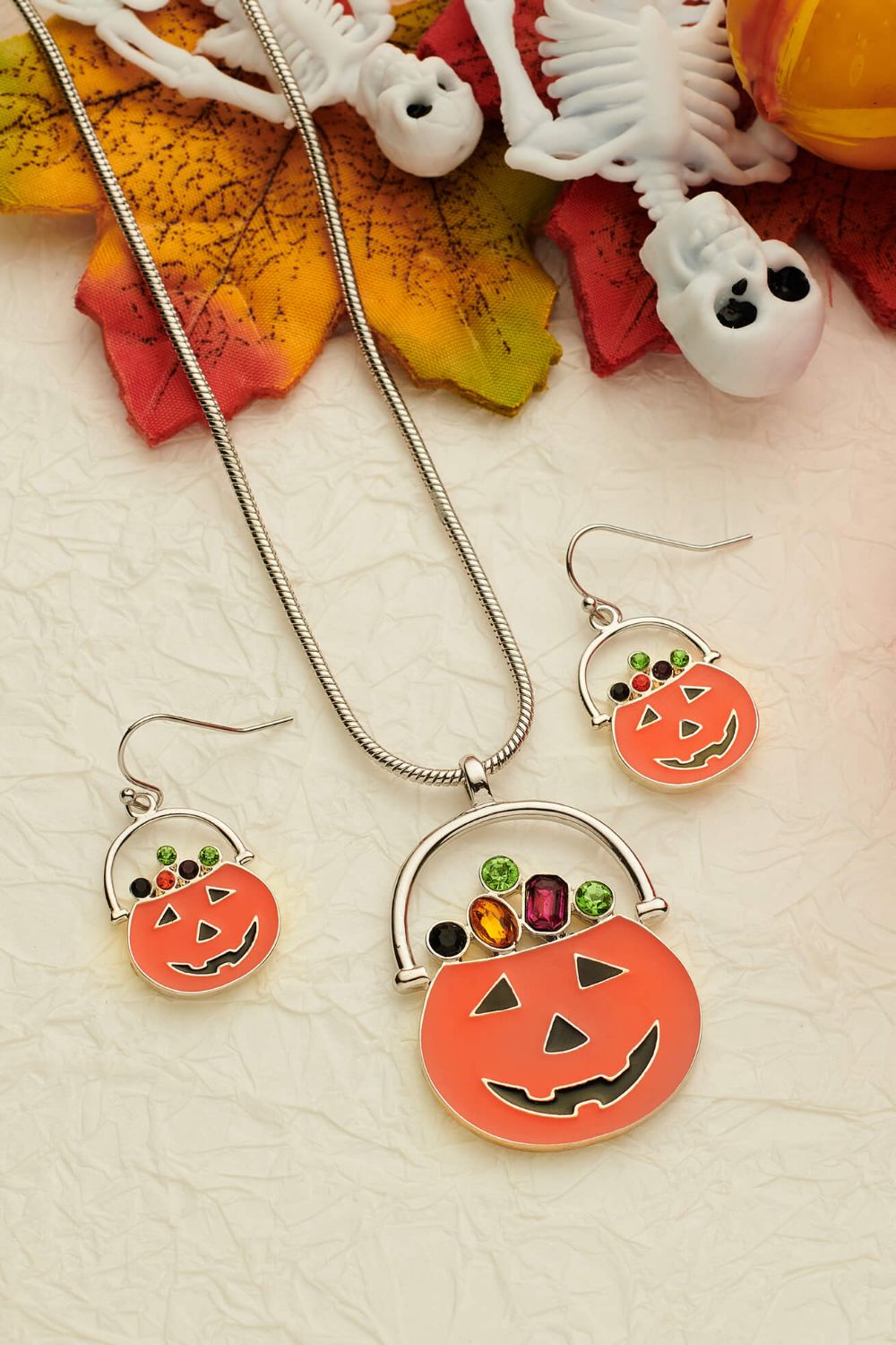 Halloween themed dangle earrings and necklace set featuring rhinestones on a flat lay background.