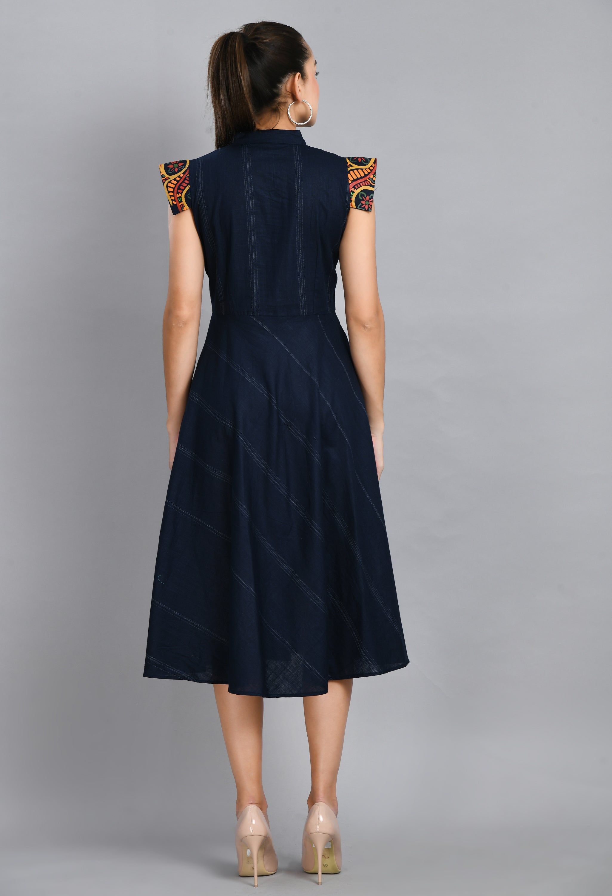 A beautiful blue linen dress featuring hand-painted sleeves and buttons, showcasing unique artistic designs.