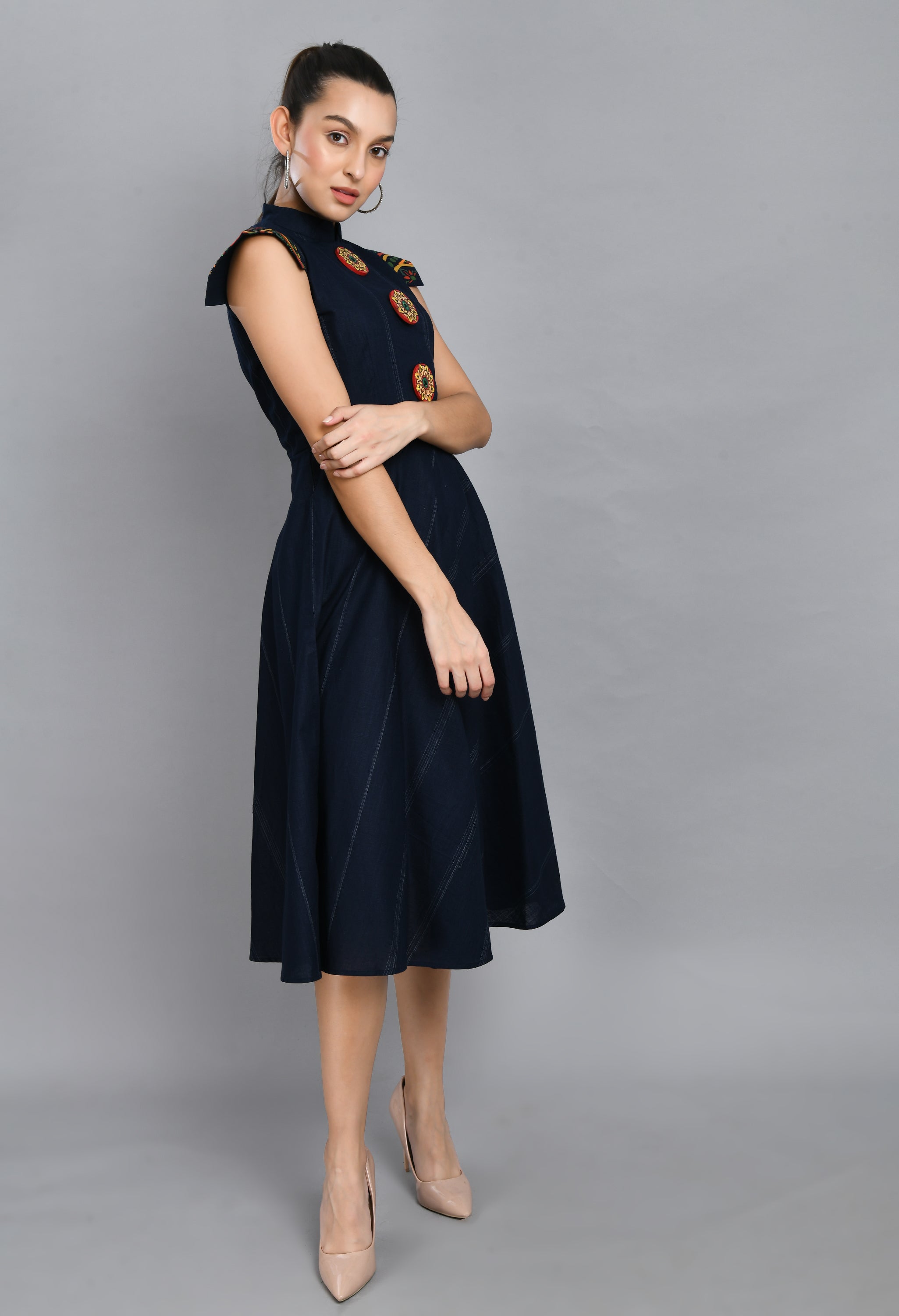 A beautiful blue linen dress featuring hand-painted sleeves and buttons, showcasing unique artistic designs.