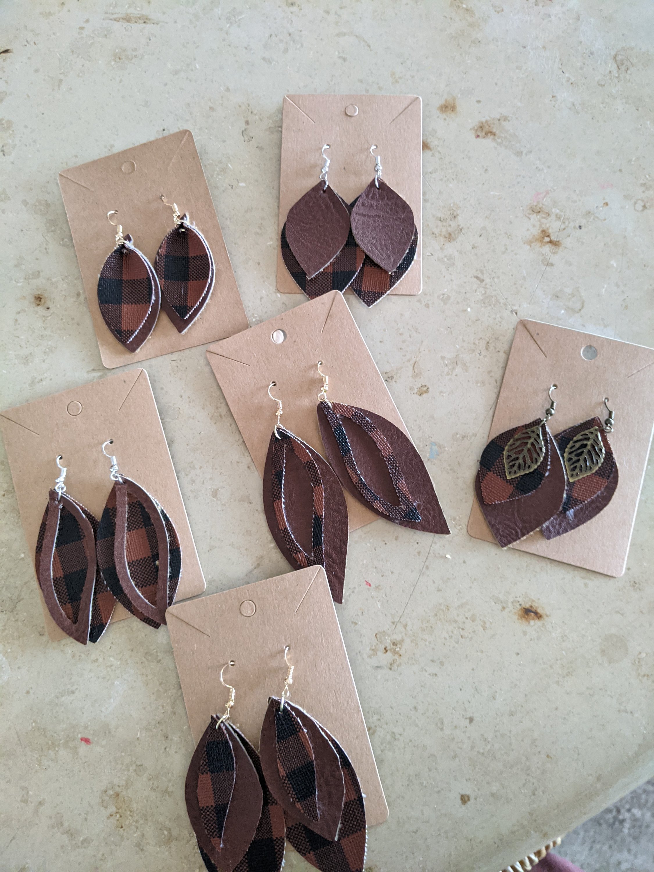 Handmade brown faux leather earrings featuring a unique buffalo print design, perfect for stylish accessorizing.