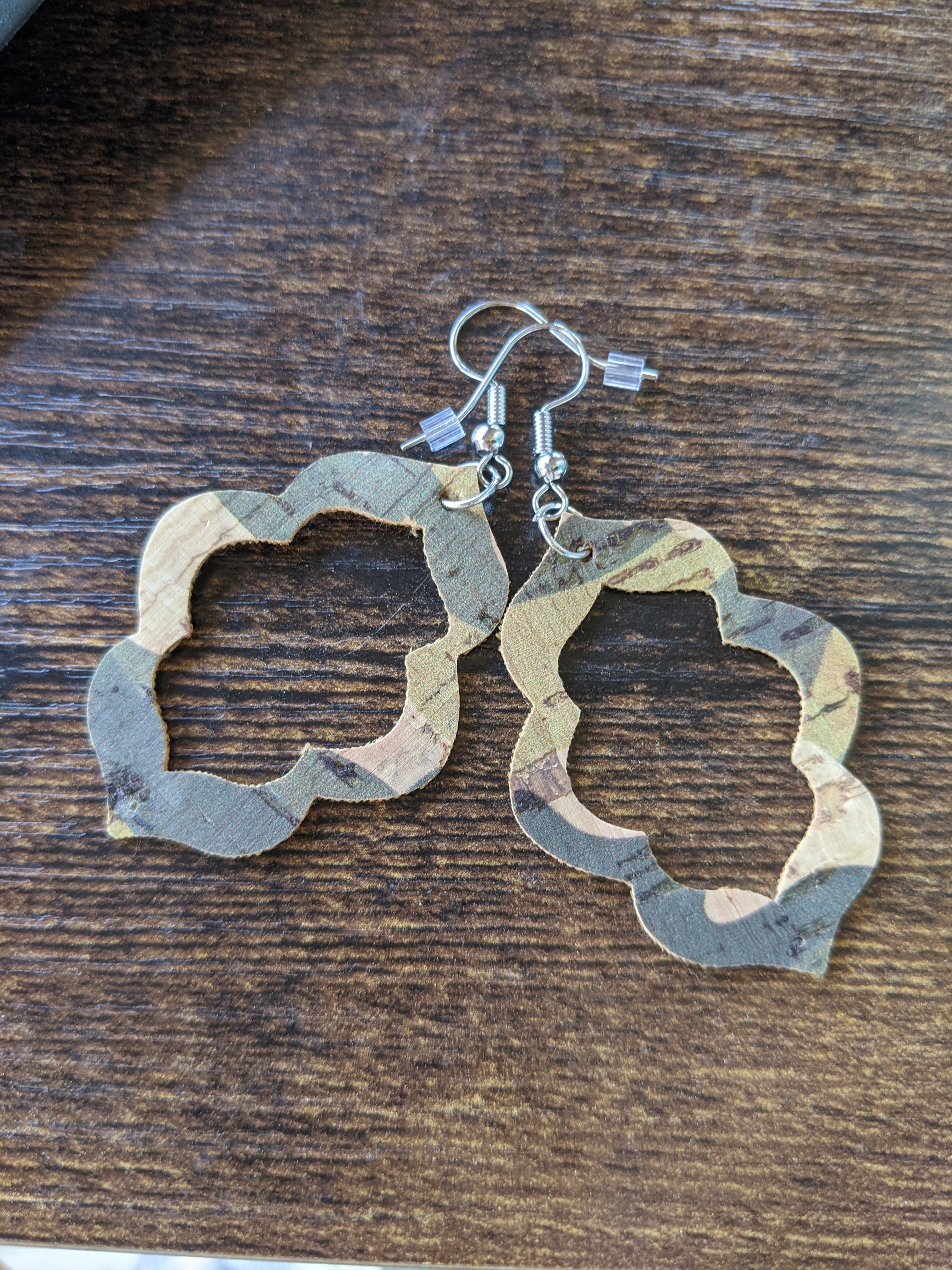 A pair of handmade camo cork earrings, lightweight and stylish, measuring about an inch long, showcasing unique patterns.