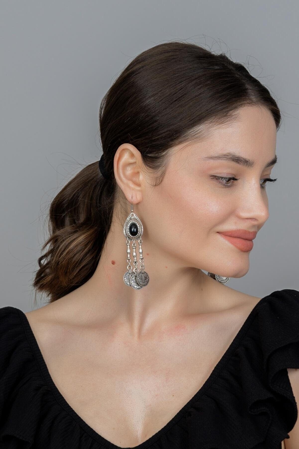 A pair of handmade silver-plated antique earrings featuring a boho tribal goddess design, showcasing intricate details and a shiny finish.