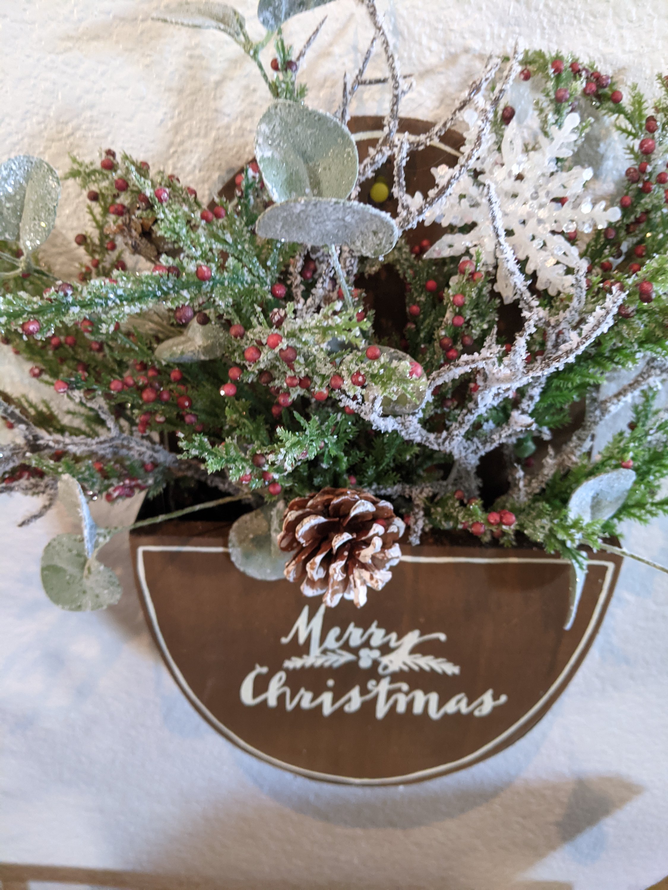 Handmade wooden Merry Christmas box featuring winter greenery and vibrant berries, perfect for holiday decor.