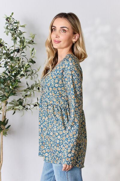 Heimish Full Size Floral Half Button Long Sleeve Blouse featuring a chic notched neckline and vibrant floral pattern.