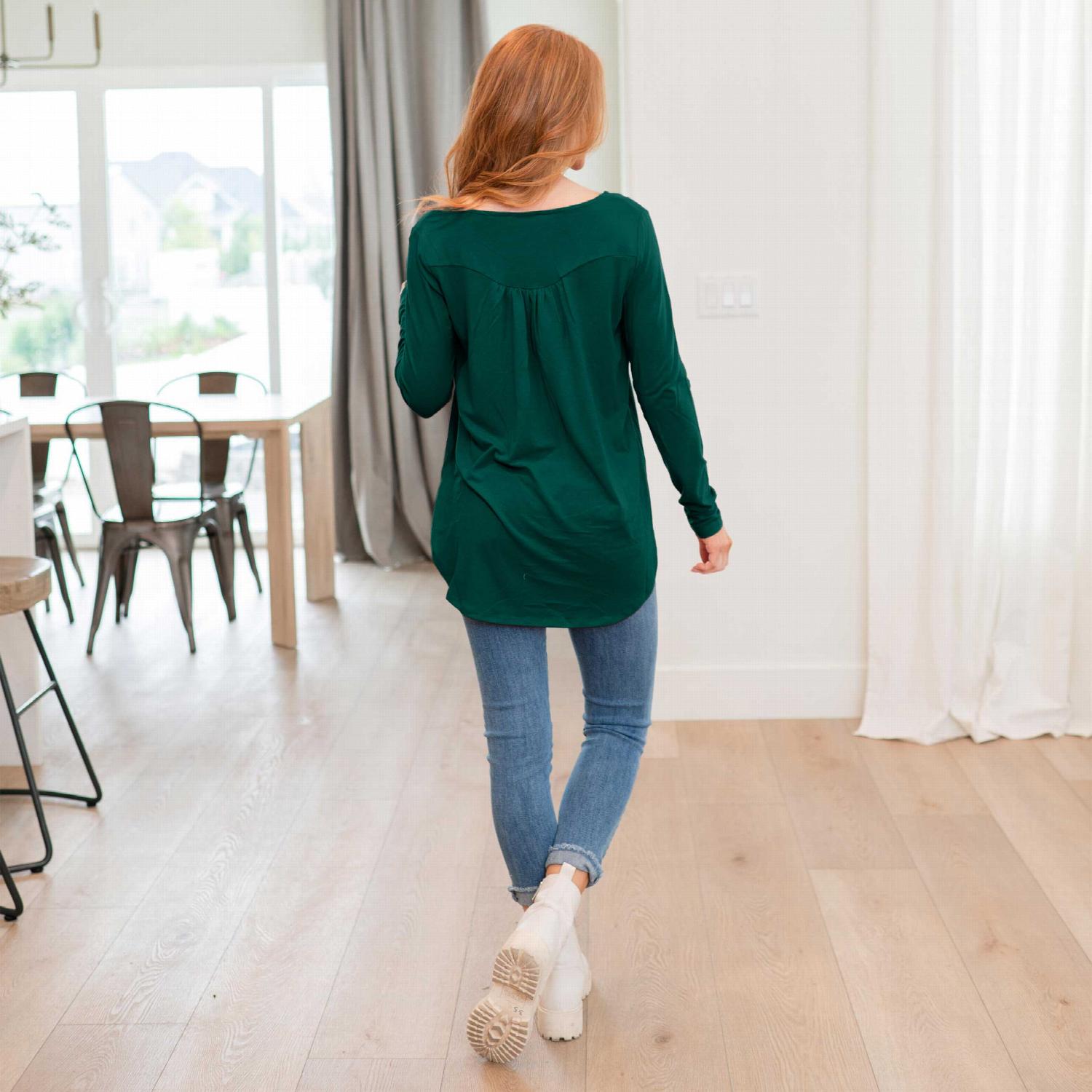 A stylish Henley Neck With Yoke Shirring Top featuring a button front, baby doll fit, and yoke shirring tunic hemline, perfect for versatile outfits.