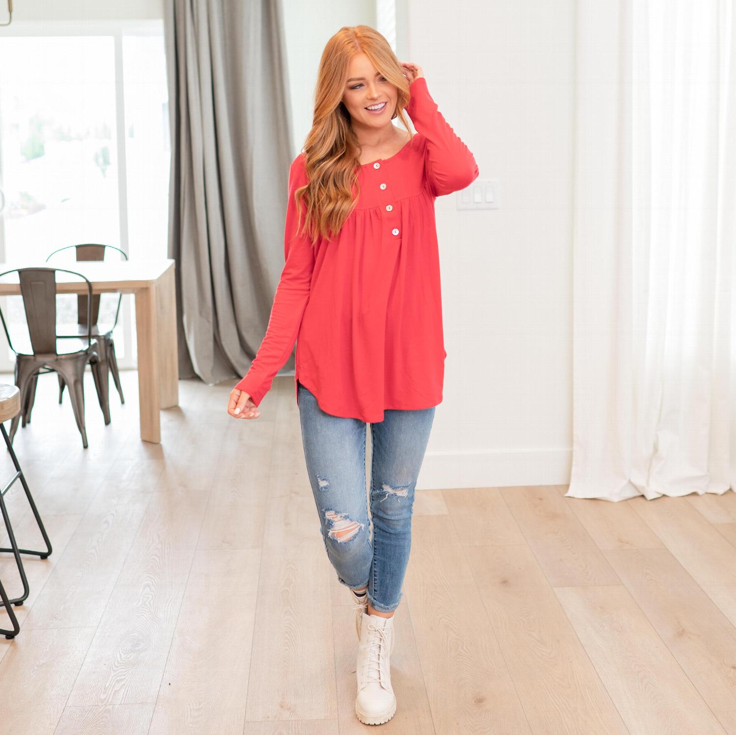 A stylish Henley Neck With Yoke Shirring Top featuring a button front, baby doll fit, and yoke shirring tunic hemline, perfect for versatile outfits.
