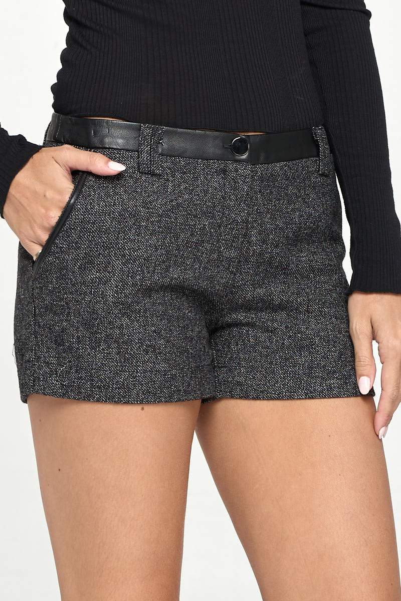 A pair of stylish vegan leather shorts with a contrast waist band, showcasing a modern design suitable for women.