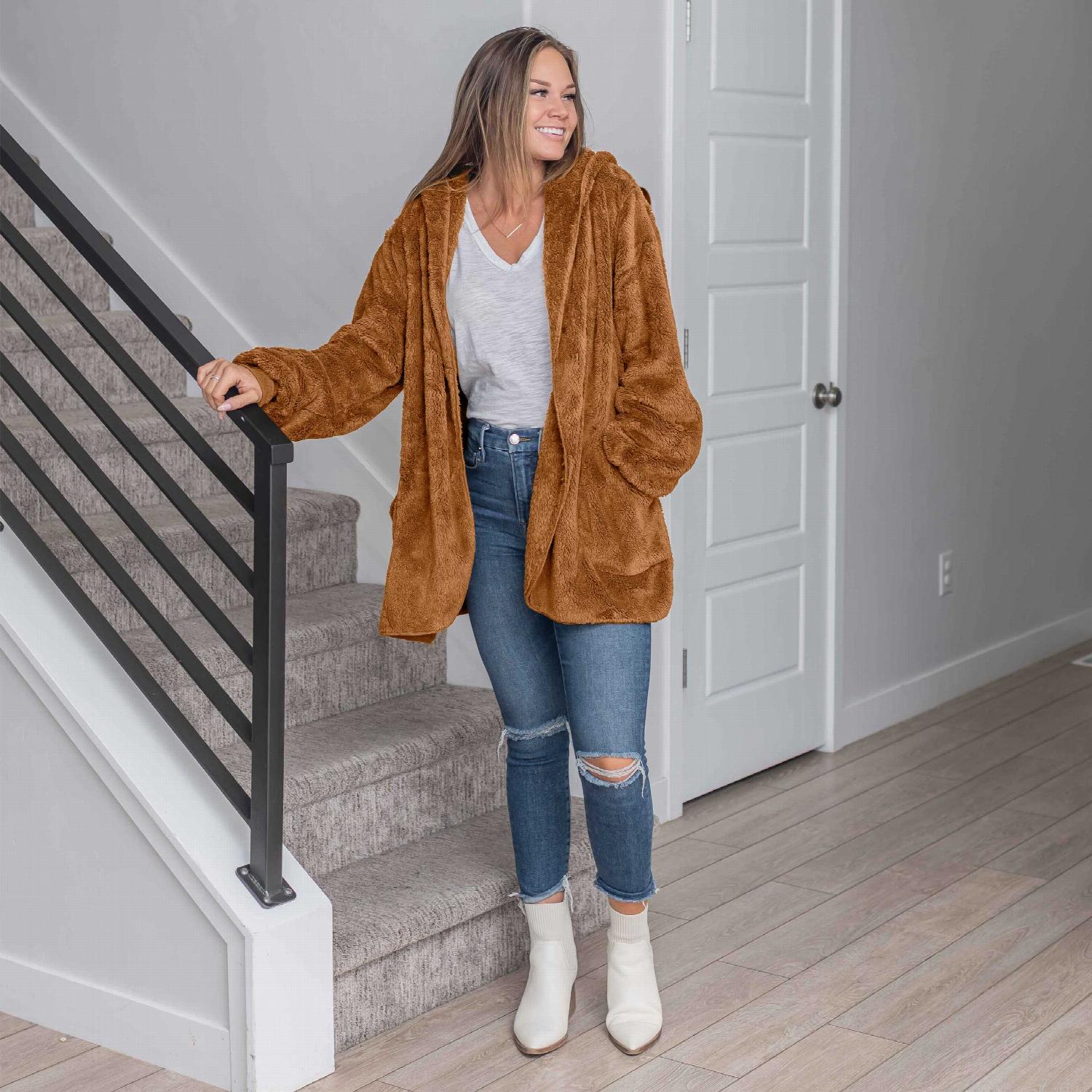 A stylish hooded faux fur jacket with large pockets, perfect for fall and winter wear.