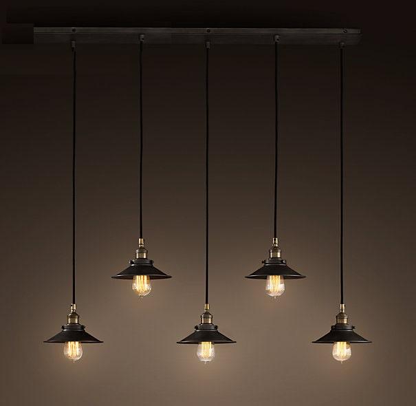 Hollie Adjustable Cord 5-light Edison Lamp with antique black finish and five shades, illuminating a stylish dining room.