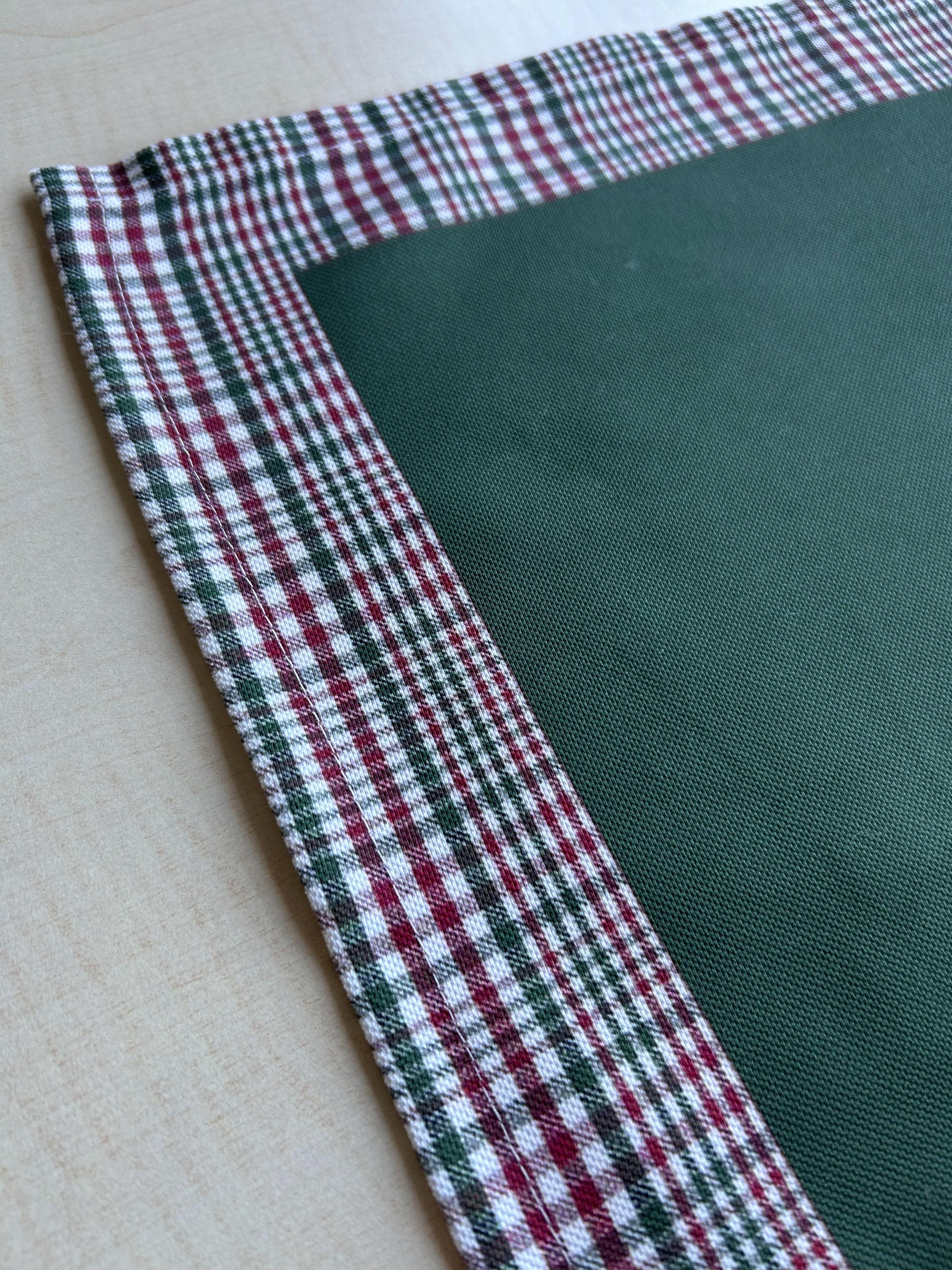 Hunter green and red plaid runner with a decorative border, perfect for holiday decor on tables or mantles.