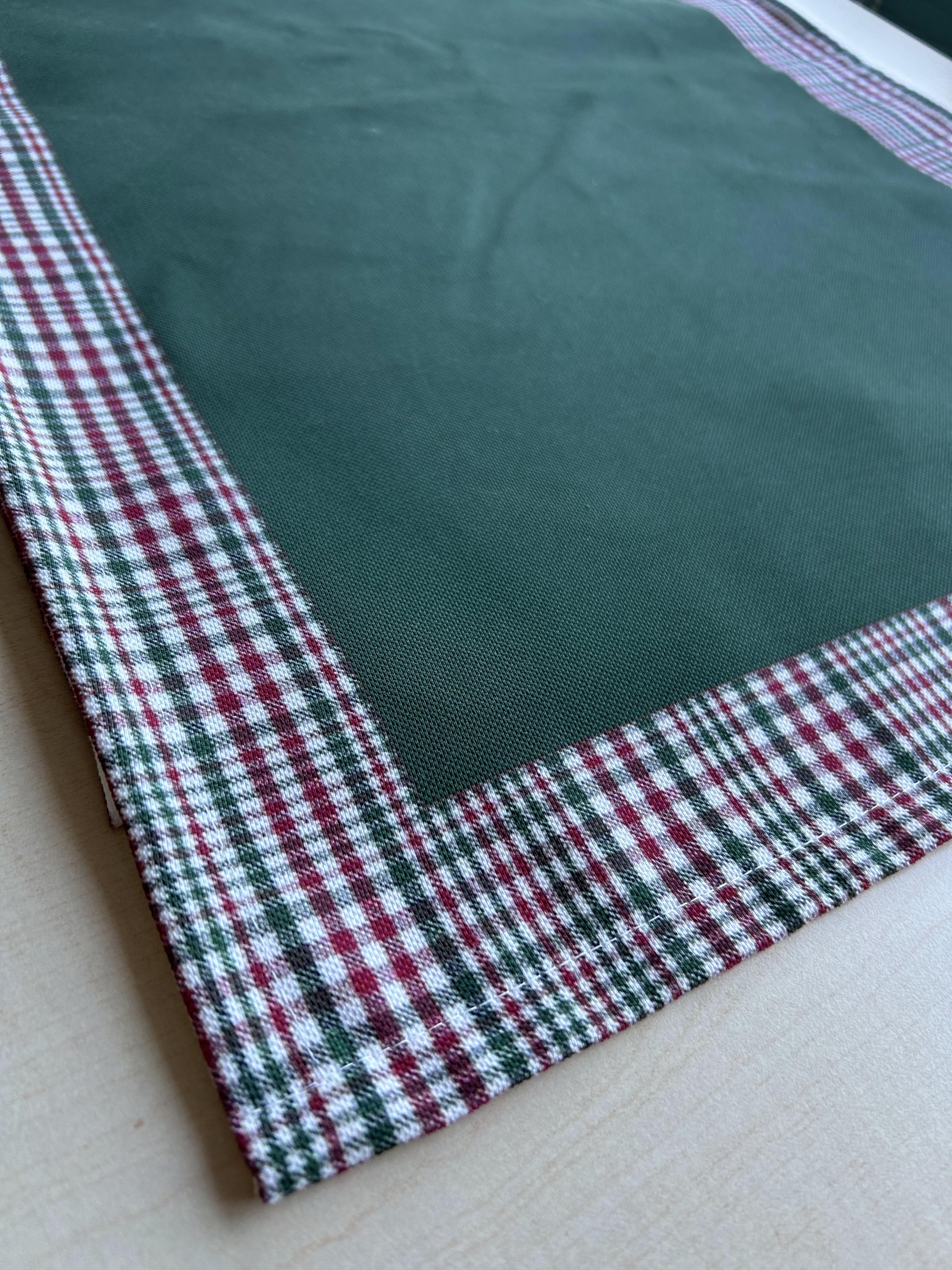 Hunter green and red plaid runner with a decorative border, perfect for holiday decor on tables or mantles.