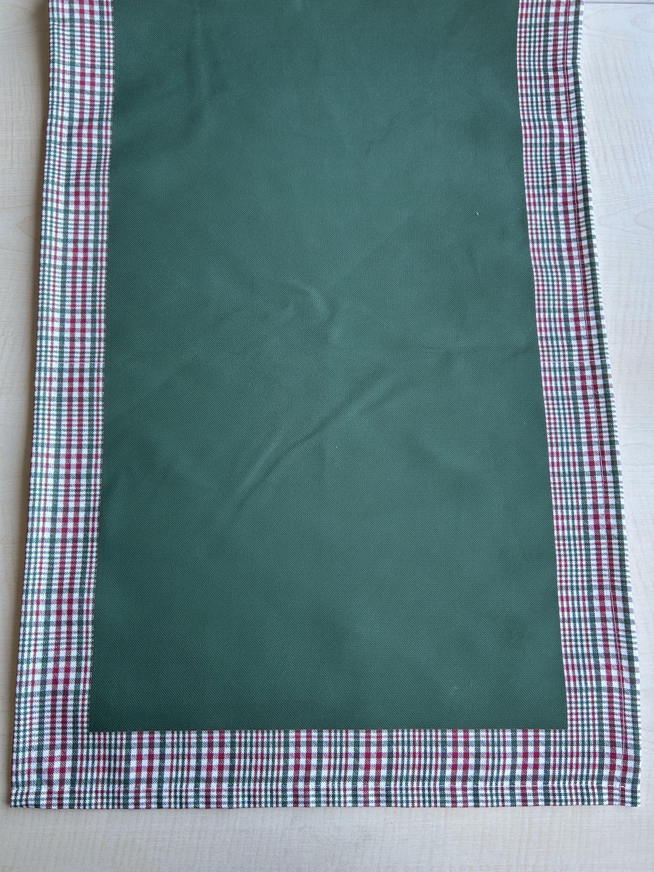 Hunter green and red plaid runner with a decorative border, perfect for holiday decor on tables or mantles.
