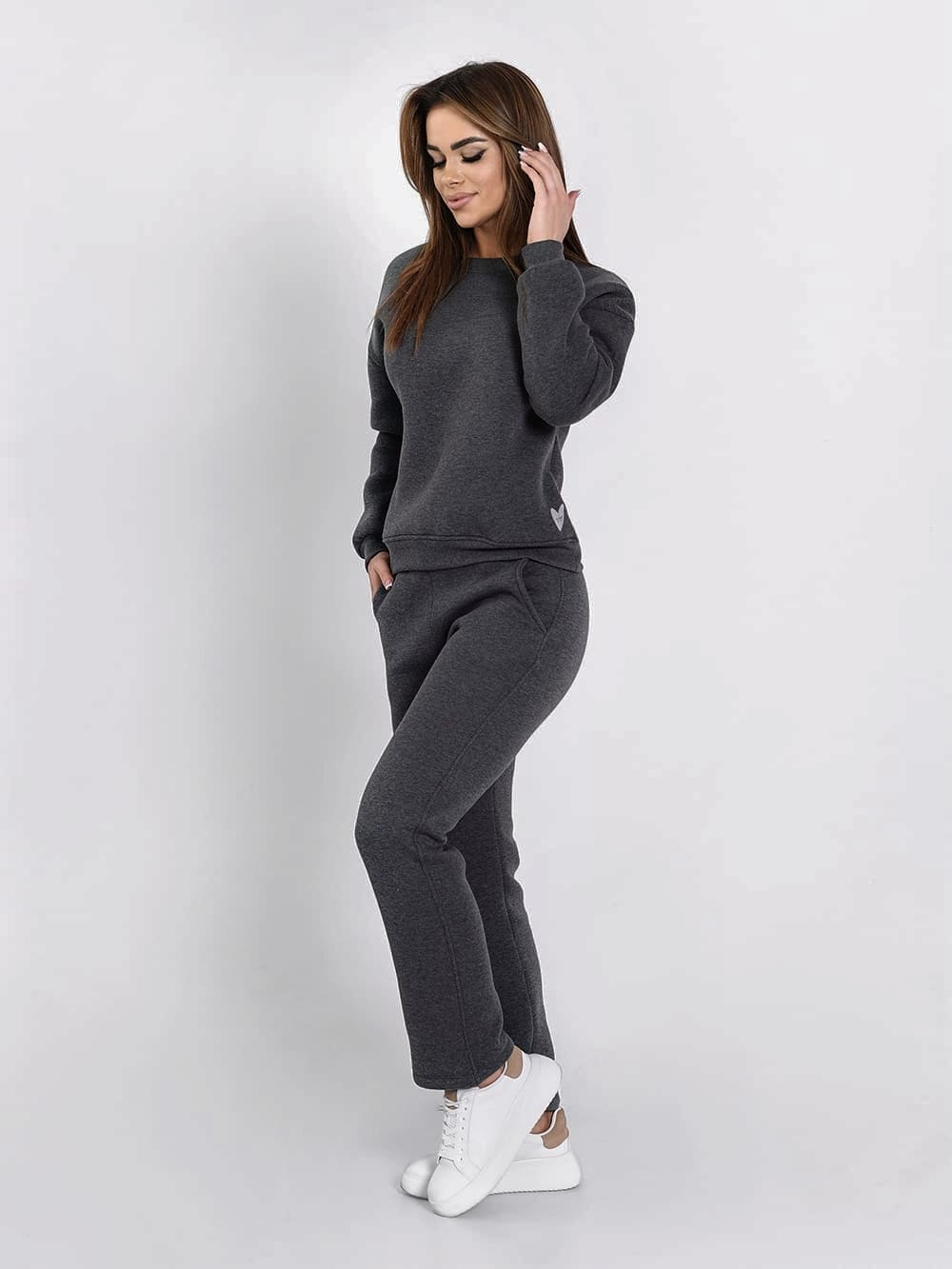 Graphite insulated tracksuit for women featuring a long-sleeved sweatshirt and loose-leg pants, perfect for fall and winter.
