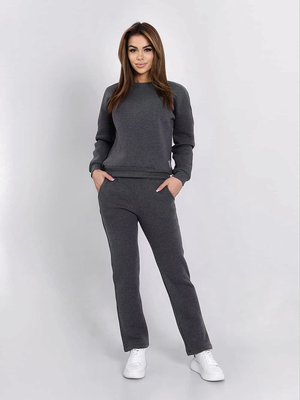 Graphite insulated tracksuit for women featuring a long-sleeved sweatshirt and loose-leg pants, perfect for fall and winter.