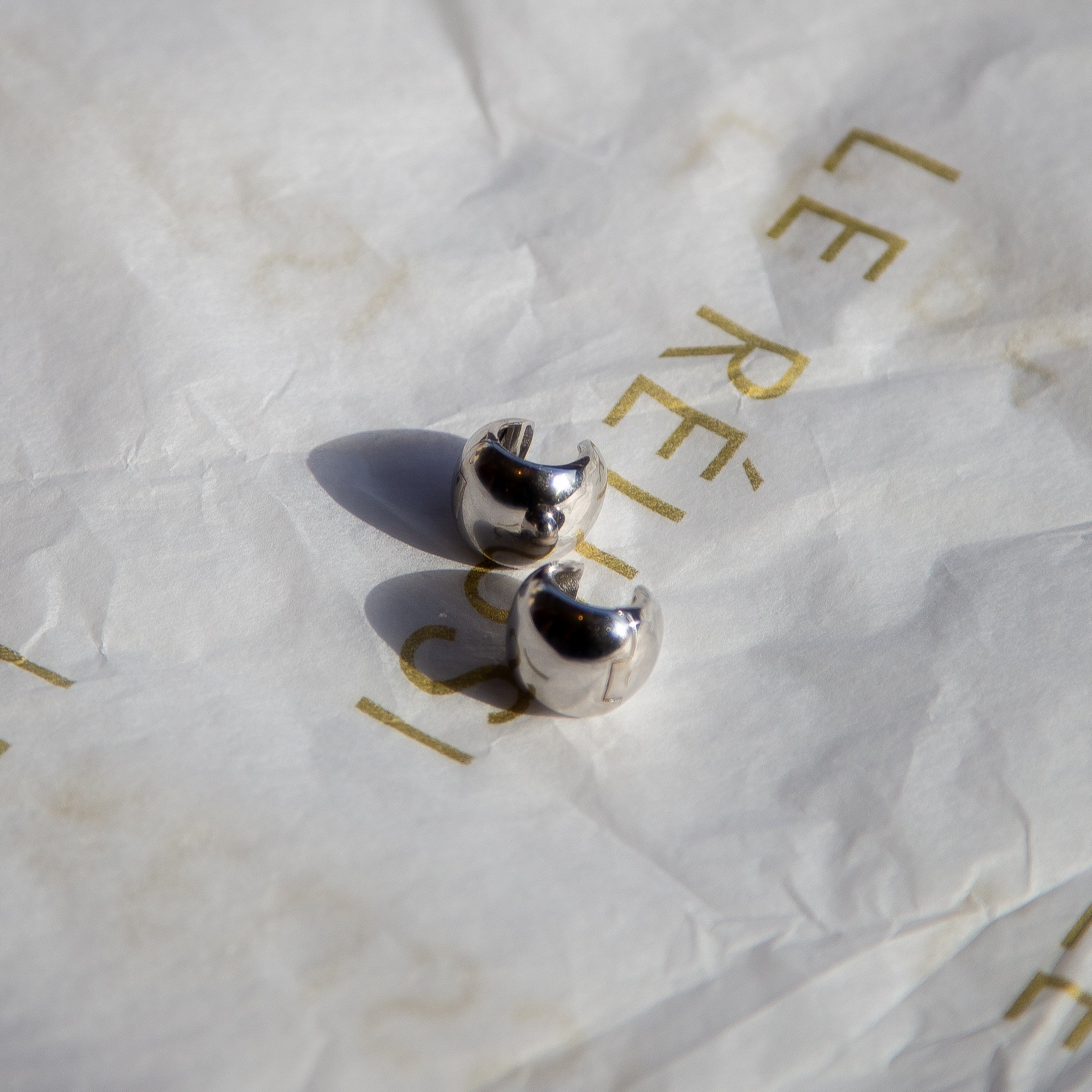 A pair of elegant Italian silver earrings shaped like peanuts, showcasing their unique design and shiny finish.