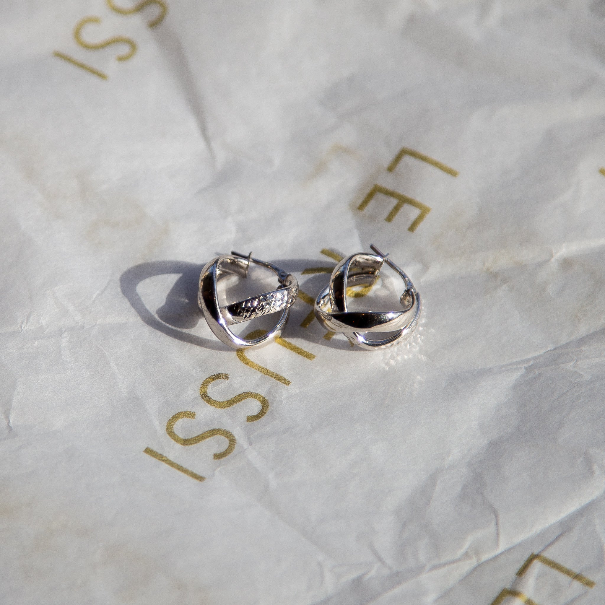 A pair of elegant Italian Twisted Duo Silver Hoop Earrings showcasing a unique twisted design in sterling silver.