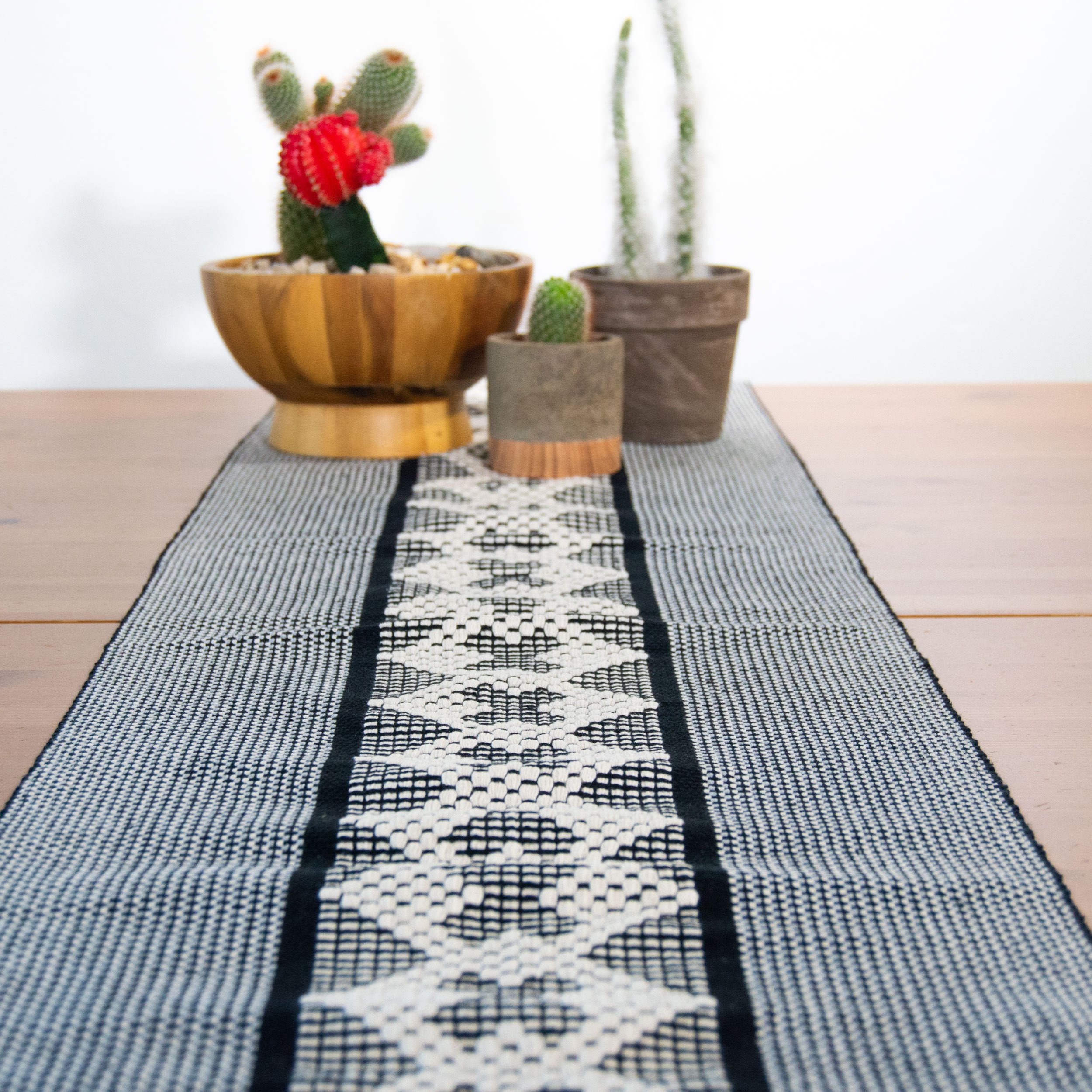 Jalieza Geometric Table Runner featuring a vibrant tulip design in coral, handcrafted on a waist loom in Oaxaca, Mexico.
