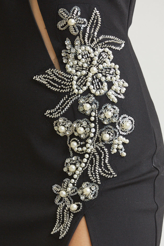 The Kennedy dress featuring a bodycon fit, sheer mesh bodice panels, and pearl bead embellishments at the hip, perfect for elegant occasions.