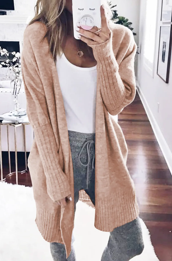 Gray knitted cardigan with pockets and ribbed details, showcasing long sleeves and mid-thigh length.