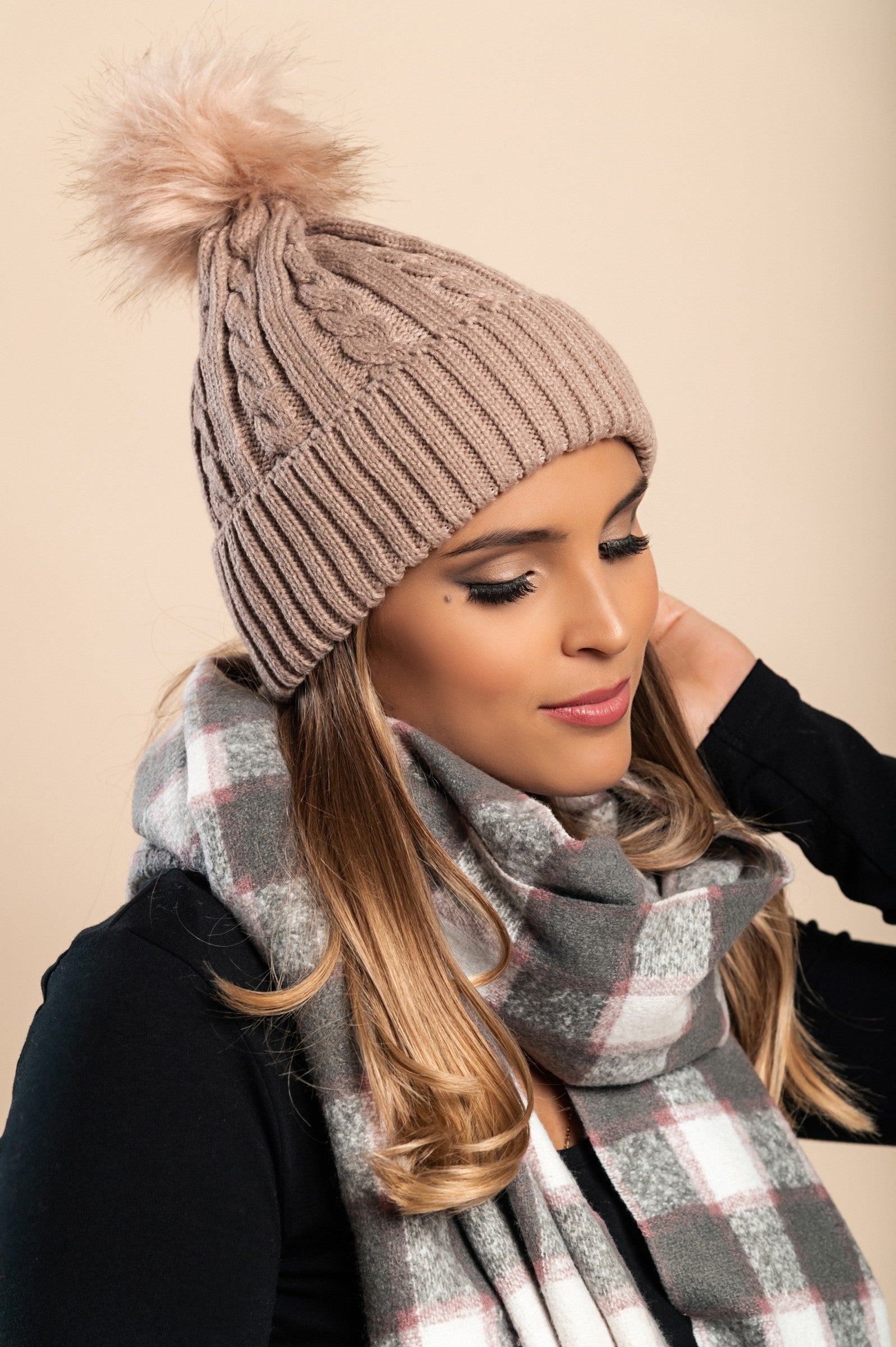 Camel knitted hat with a decorative faux fur pompom on top, showcasing a rolled edge design.