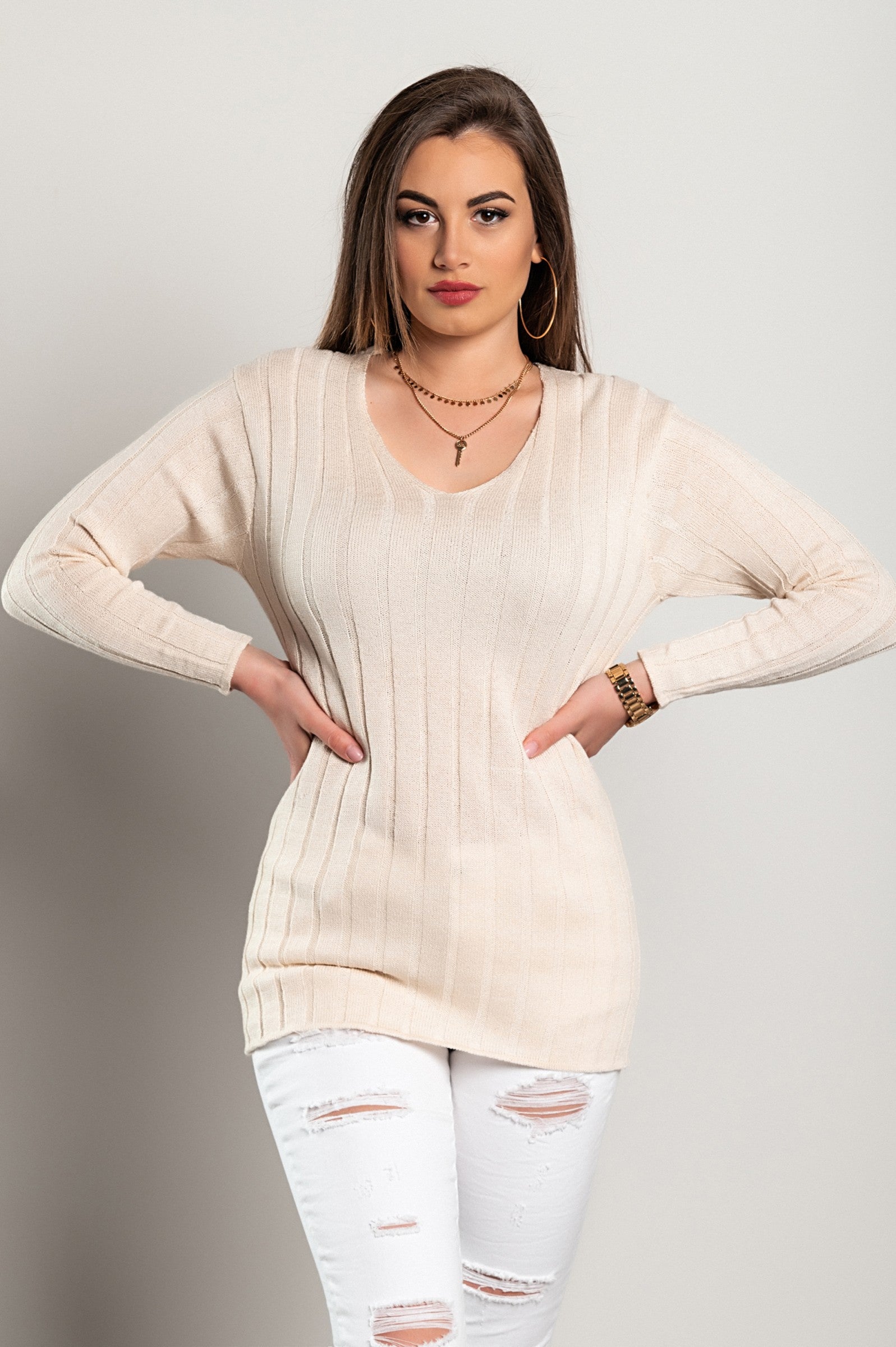 Beige knitted mini dress with long sleeves and V neckline, showcasing a fitted design and mid-thigh length, made in Italy.