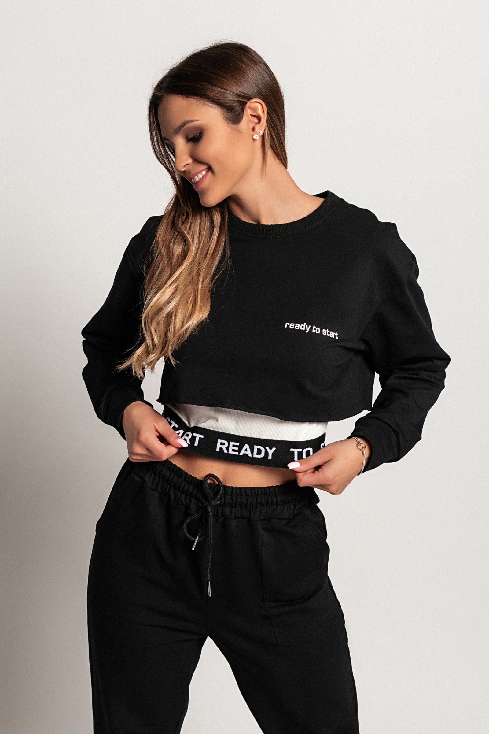 Komplet športne majice in topa Malfa v črni barvi, prikazuje ohlapno majico z dolgimi rokavi in športni top brez rokavov.