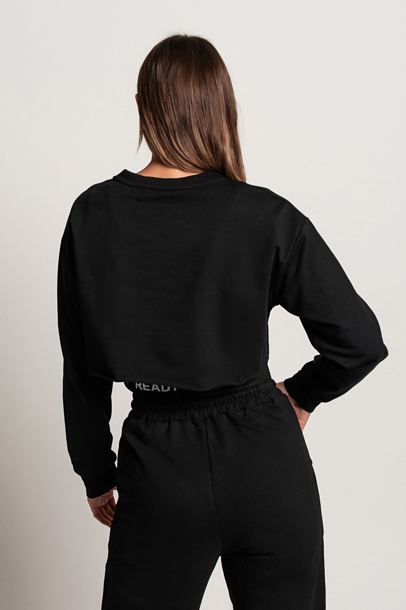 Komplet športne majice in topa Malfa v črni barvi, prikazuje ohlapno majico z dolgimi rokavi in športni top brez rokavov.