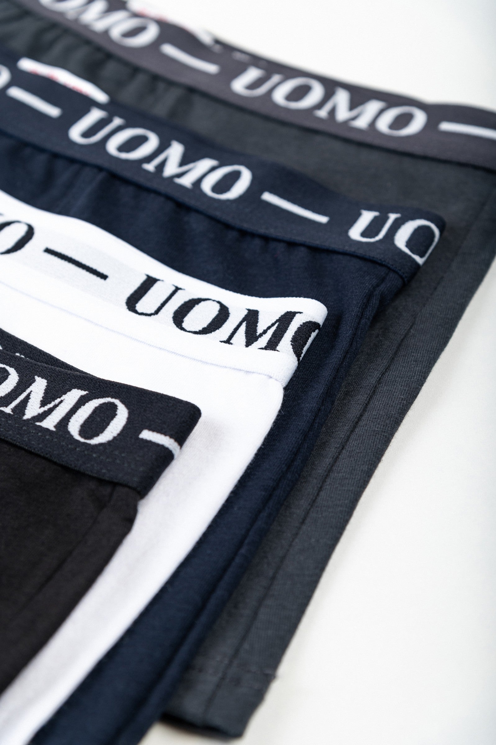 Komplet štirih moških bokser hlačk v belih, sivih, črnih in temno modrih barvah, izdelan iz bombaža in elastana.