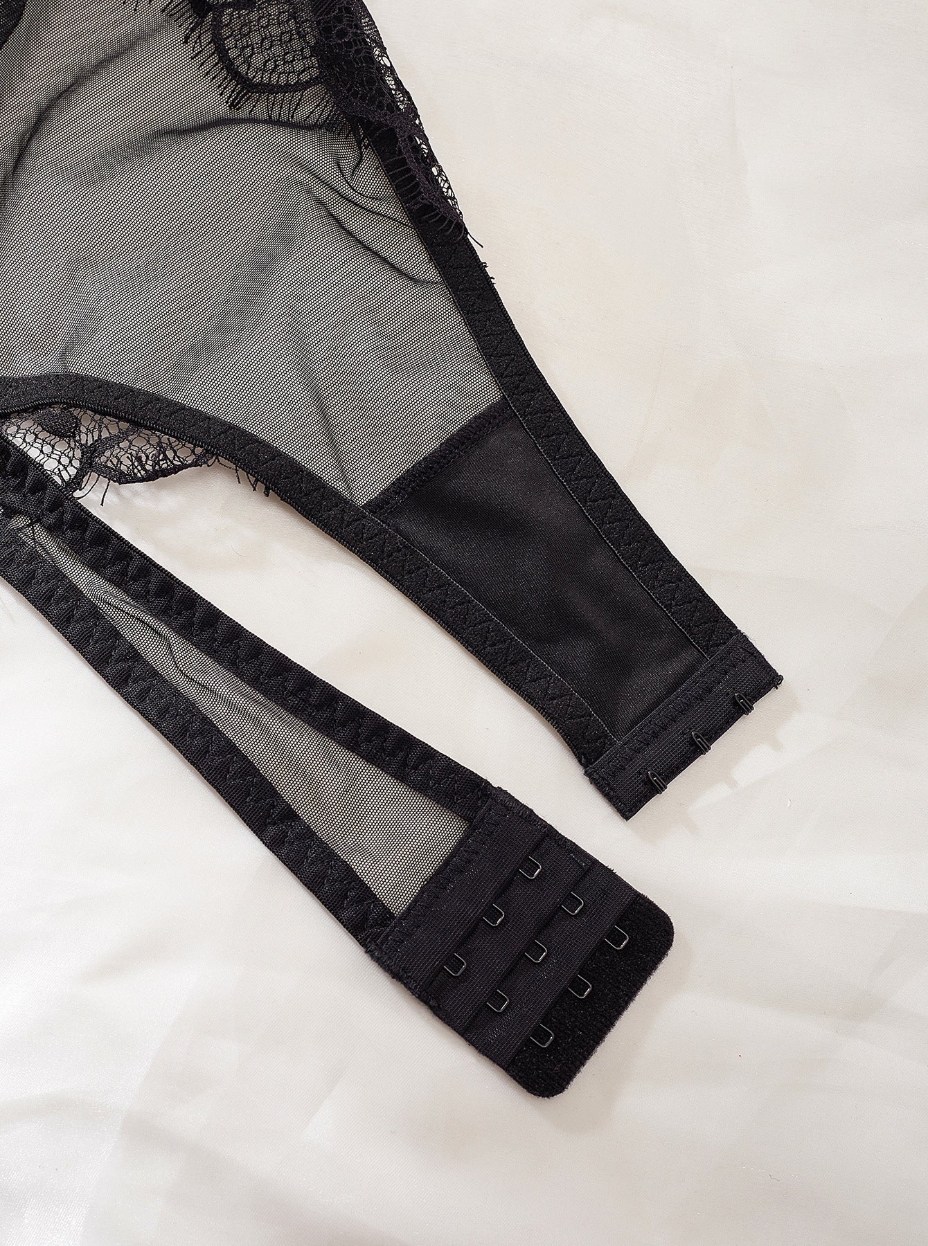 A sexy backless jumpsuit featuring intricate lace stitching and a see-through mesh design, perfect for stylish occasions.