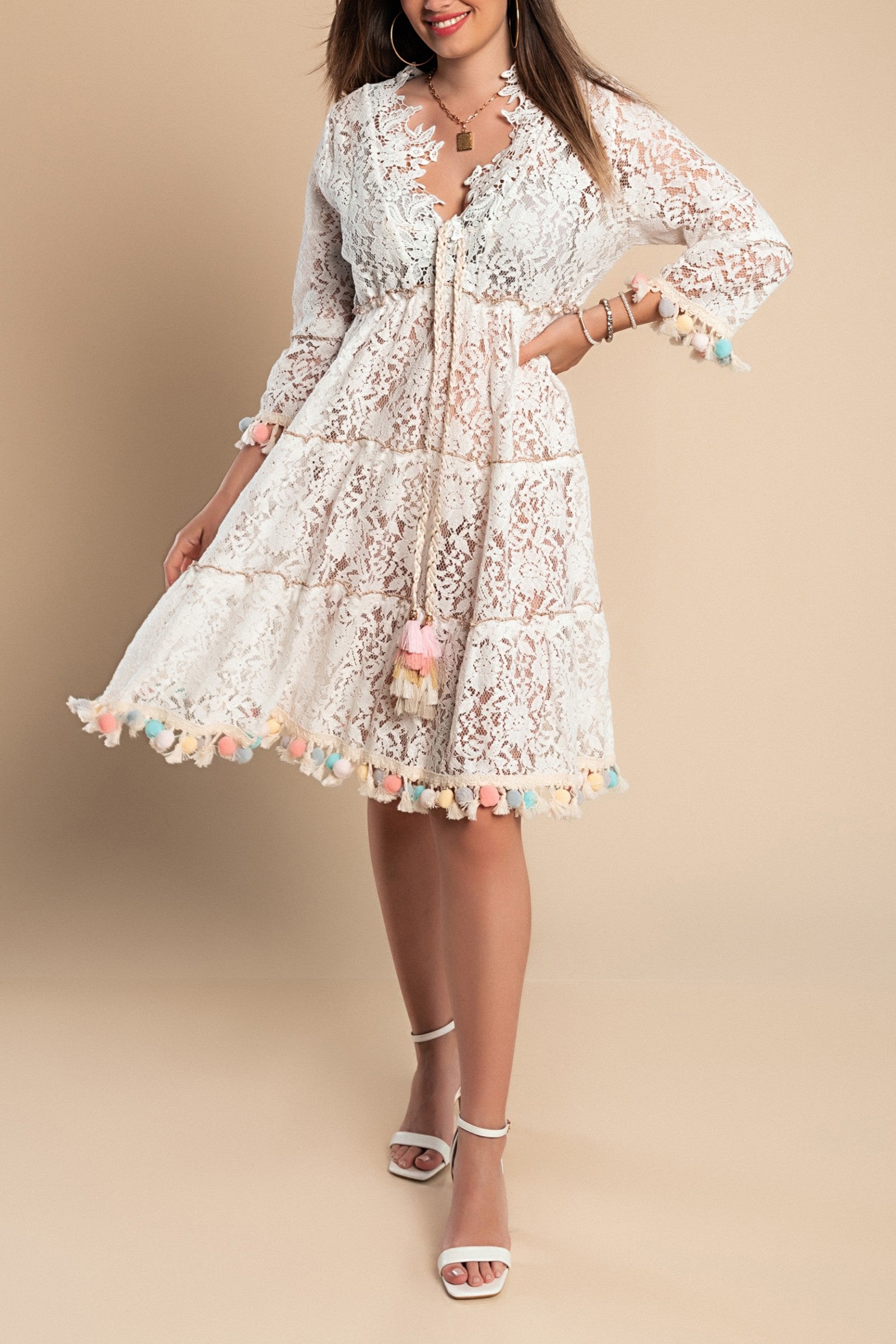 Lace Summer Maxi Dress Tribiana in white, featuring a deep V neckline, long sleeves, and decorative pom pom details.