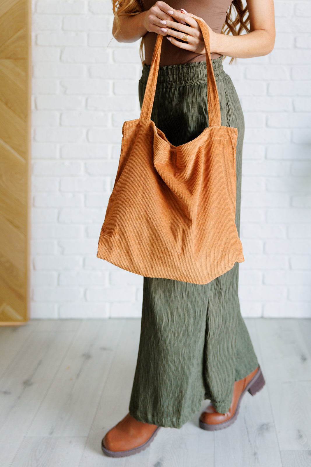 Last Minute Corduroy Tote in Brown showcasing its stylish design and spacious interior with pockets.