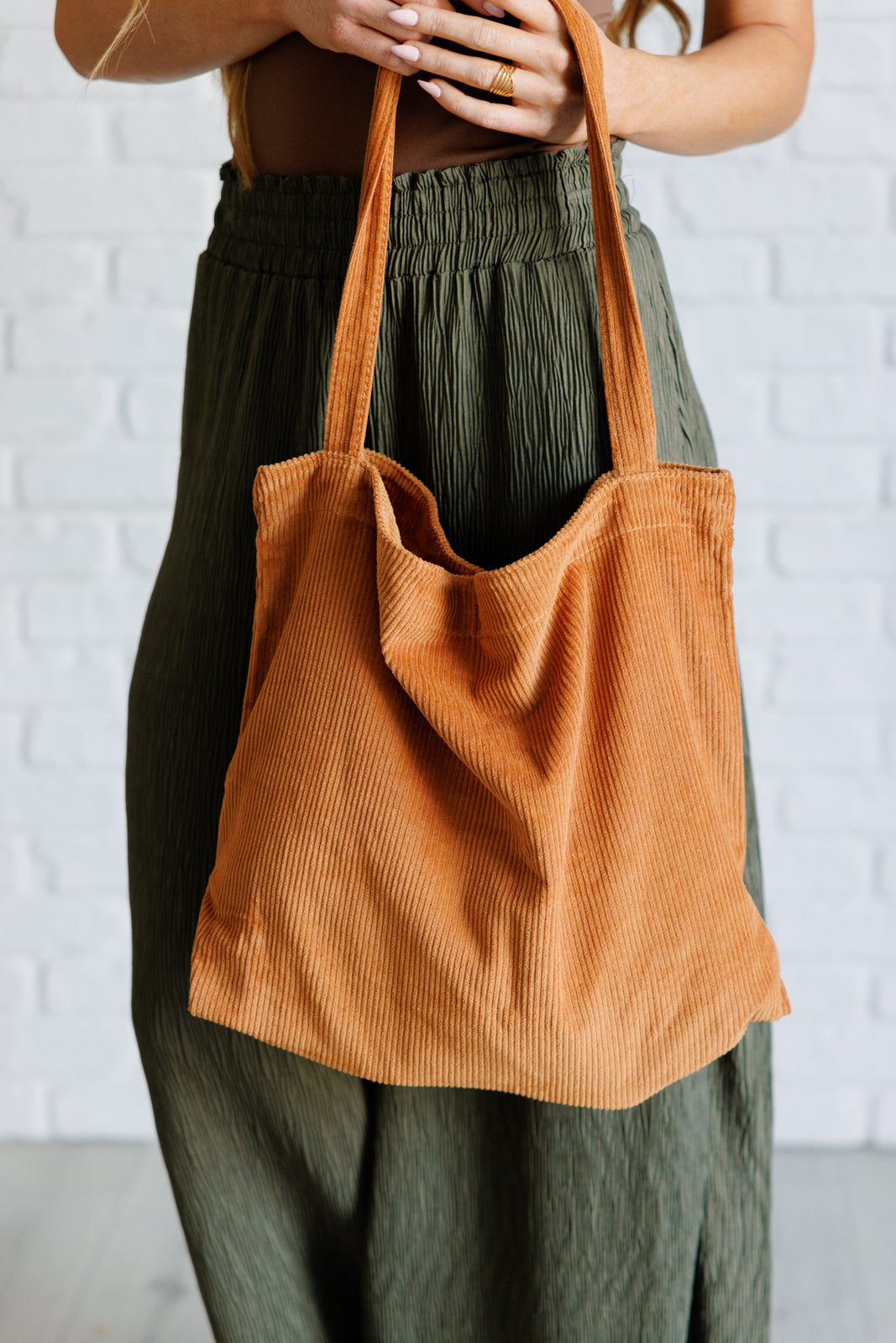 Last Minute Corduroy Tote in Brown showcasing its stylish design and spacious interior with pockets.