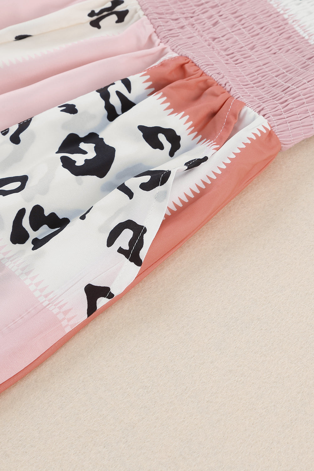 Leopard Color Block Smocked Jumpsuit featuring a stylish design with pockets and a sleeveless fit.