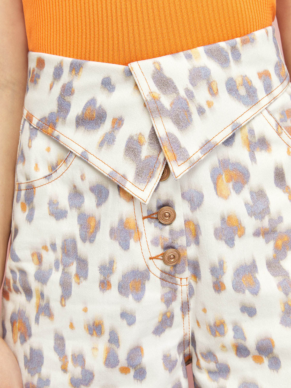 High-waisted leopard print denim shorts with cuffed hem and five pockets, showcasing a trendy design with scorched orange details.