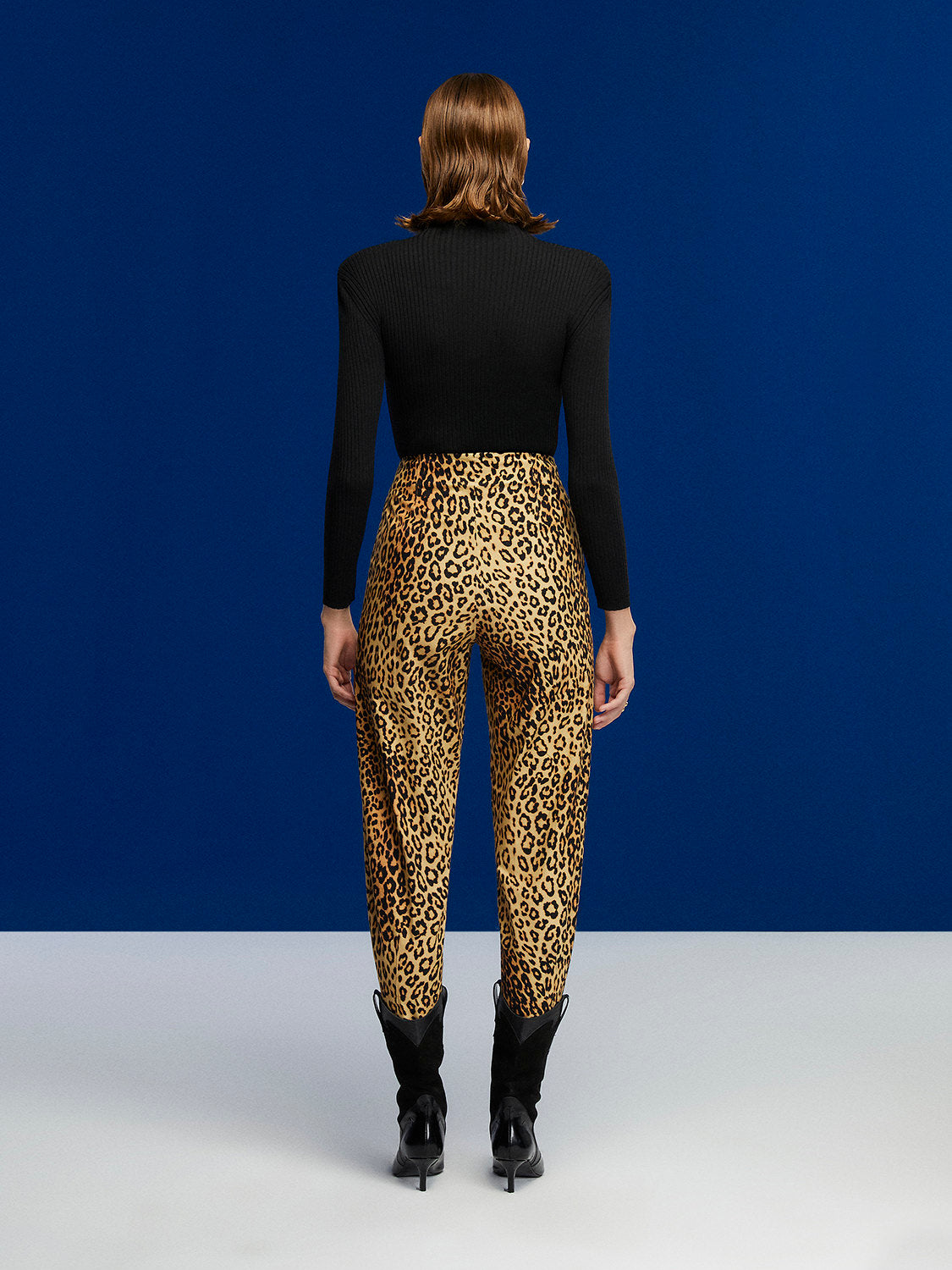 A pair of high-waisted leopard print slouchy pants with side pockets and pleat details, showcasing a trendy and stylish design.