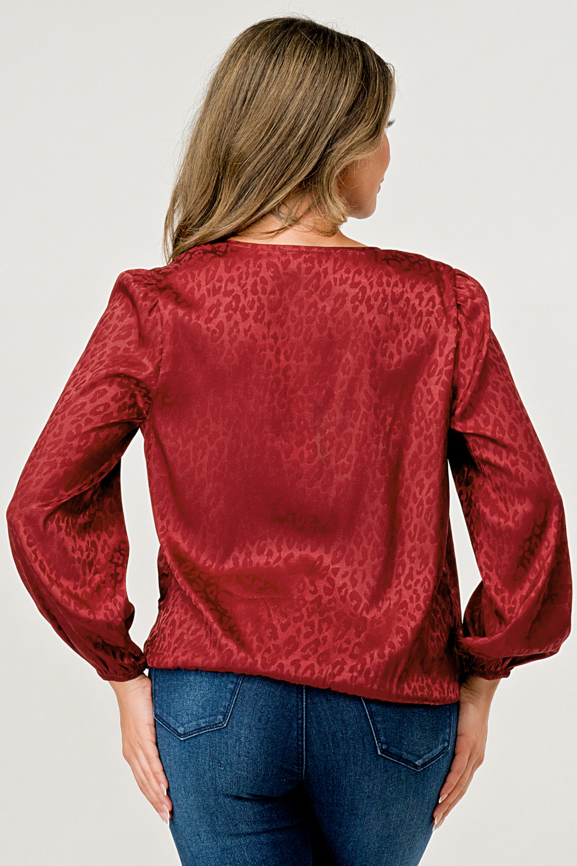 Leopard Print V-Neck Wrap Blouse with long sleeves and elastic waist, showcasing a chic satin finish and elegant jacquard pattern.